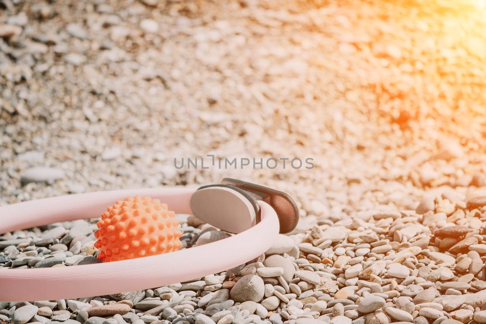 Pilates magic ring and rubber band on yoga mat near sea. Female fitness yoga concept. Healthy lifestyle harmony and meditation. by panophotograph