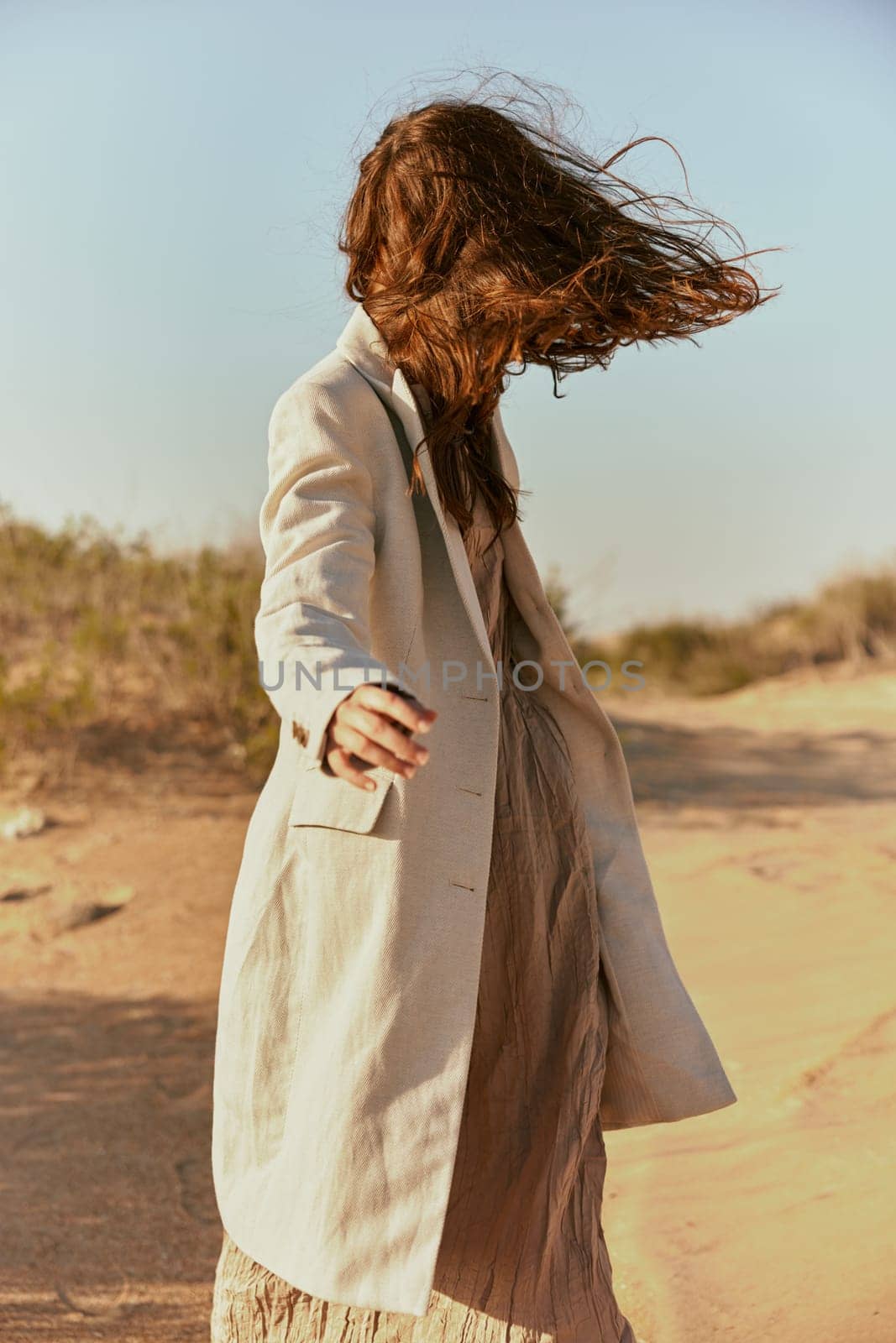 stylish woman with long red hair covering her face posing in nature. High quality photo