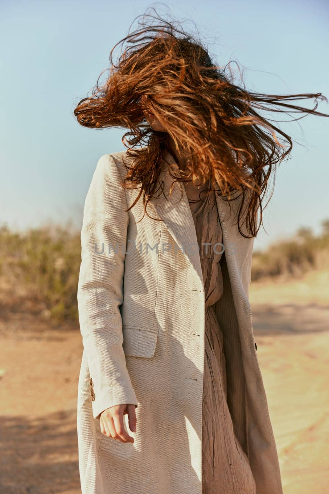 custom portrait of a woman in a light coat with red hair covering her face. High quality photo