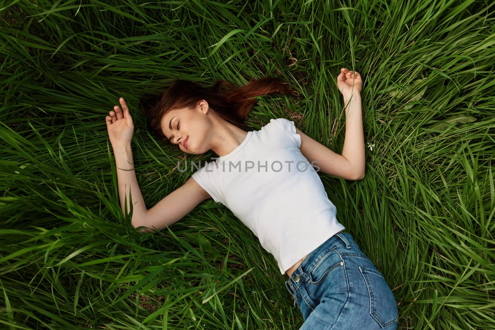 woman lies in tall grass falling asleep in nature. High quality photo