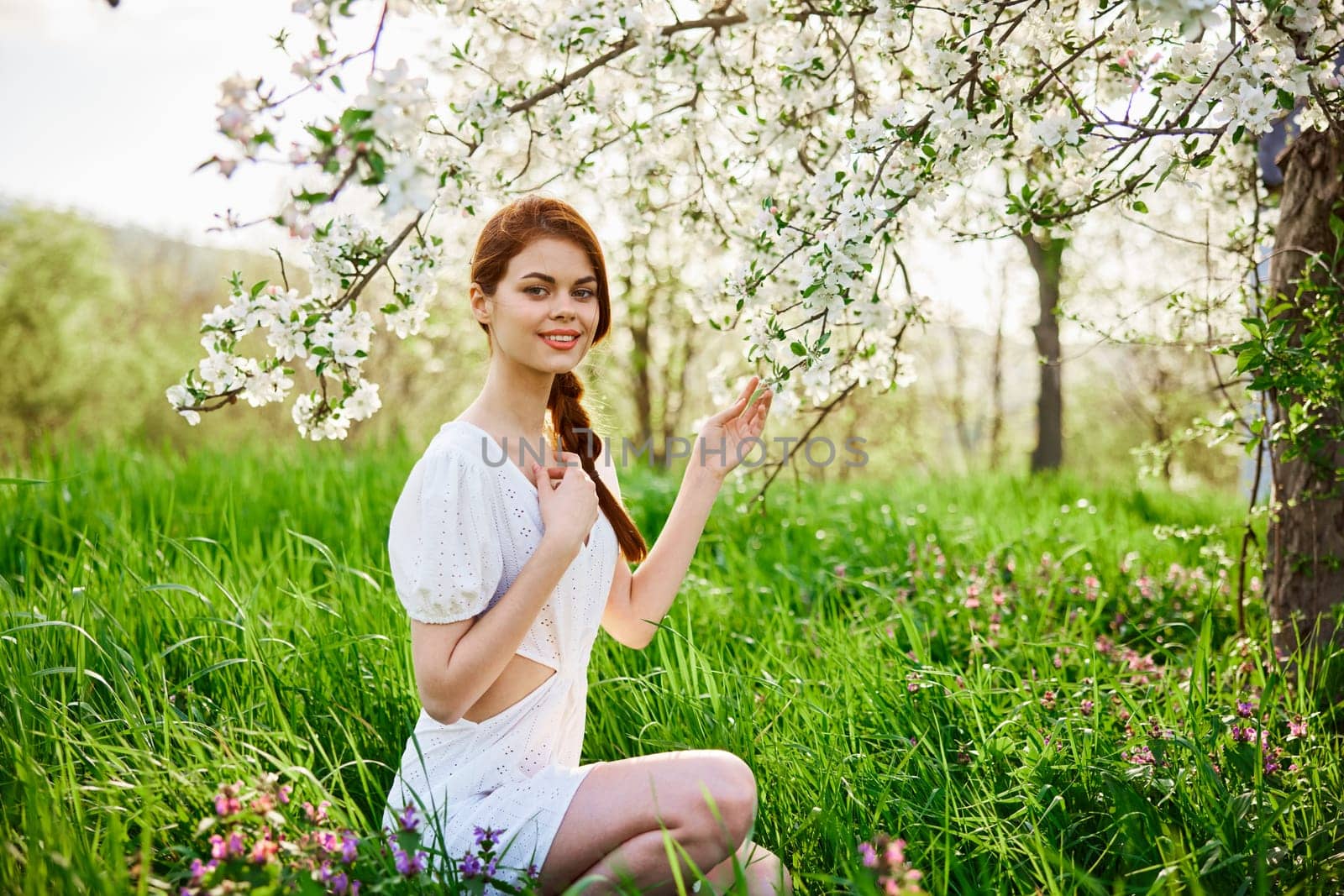 Young beautiful woman in a white dress posing in garden. High quality photo