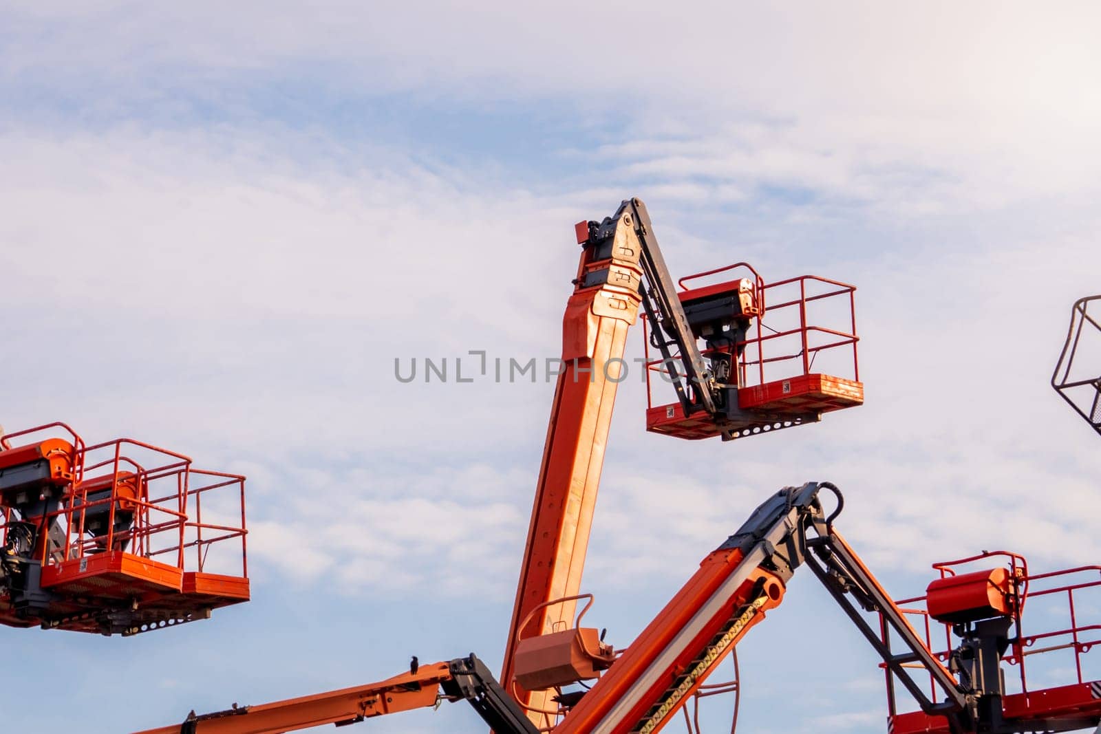 Articulated boom lift. Aerial platform lift. Telescopic boom lift against blue sky. Mobile construction crane for rent and sale. Maintenance and repair hydraulic boom lift service. Crane dealership. by Fahroni
