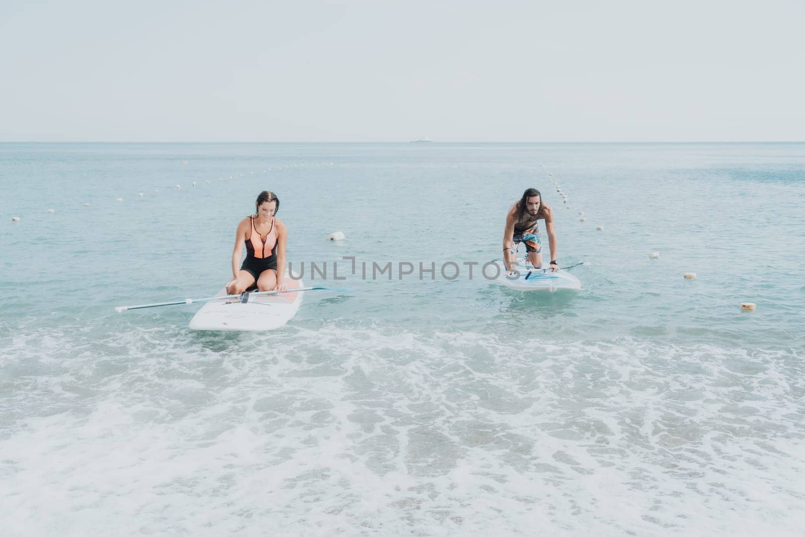 Woman man sea sup. Close up portrait of beautiful young caucasian woman with black hair and freckles looking at camera and smiling. Cute woman portrait in a pink bikini posing on sup board in the sea