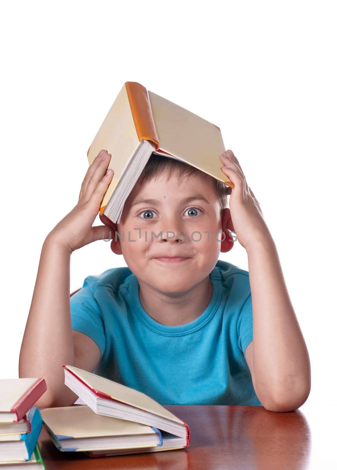 Child and books. The boy reads and plays with books. Delight on the face of the child from the books read. A preschooler is learning to read. Portrait of a boy on a white background by aprilphoto