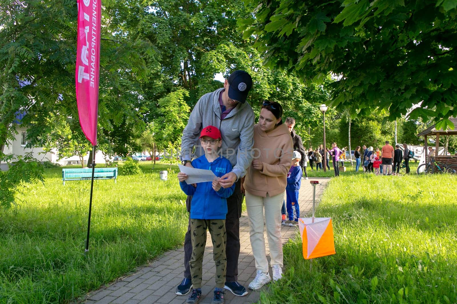 Grodno, Belarus - 15 June, 2022: Training of the Veras orienteering club . A young family of three people at the start of the route check the map and choose the direction to move.