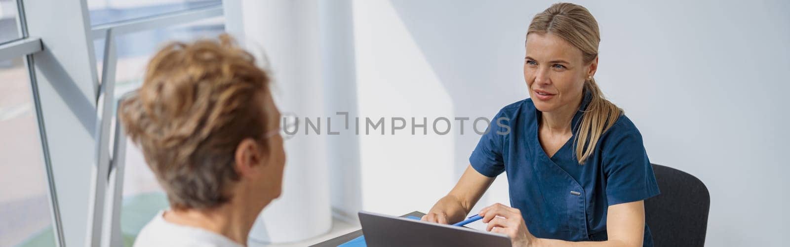 Smiling doctor fills out the medical report form on medical care of patients during appointment by Yaroslav_astakhov