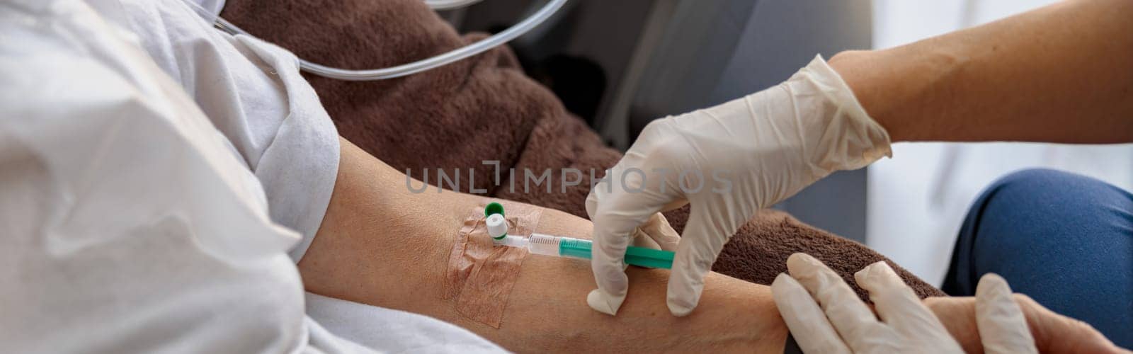 Nurse putting a drip in the arm of her patient in modern medical clinic by Yaroslav_astakhov