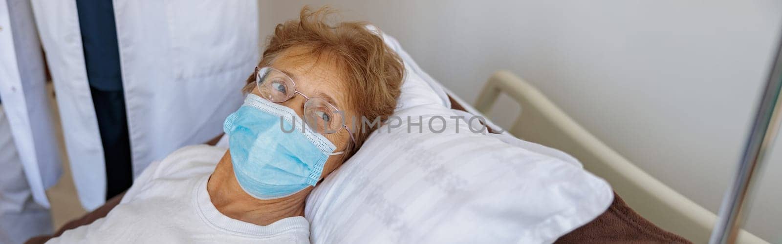 Senior female patient in mask in the ward of modern medical clinic. High quality photo