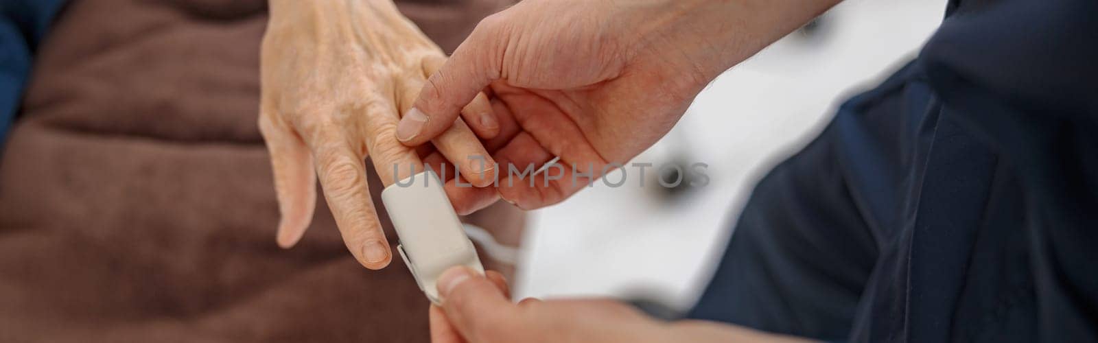 Nurse checking with fingertip pulse oximeter oxygen saturation of patient blood. High quality photo