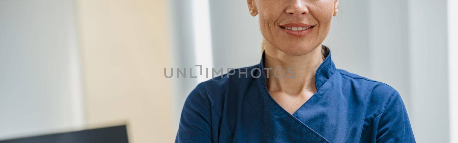 Close up of doctor in uniform standing with crossing hands in clinic. High quality photo