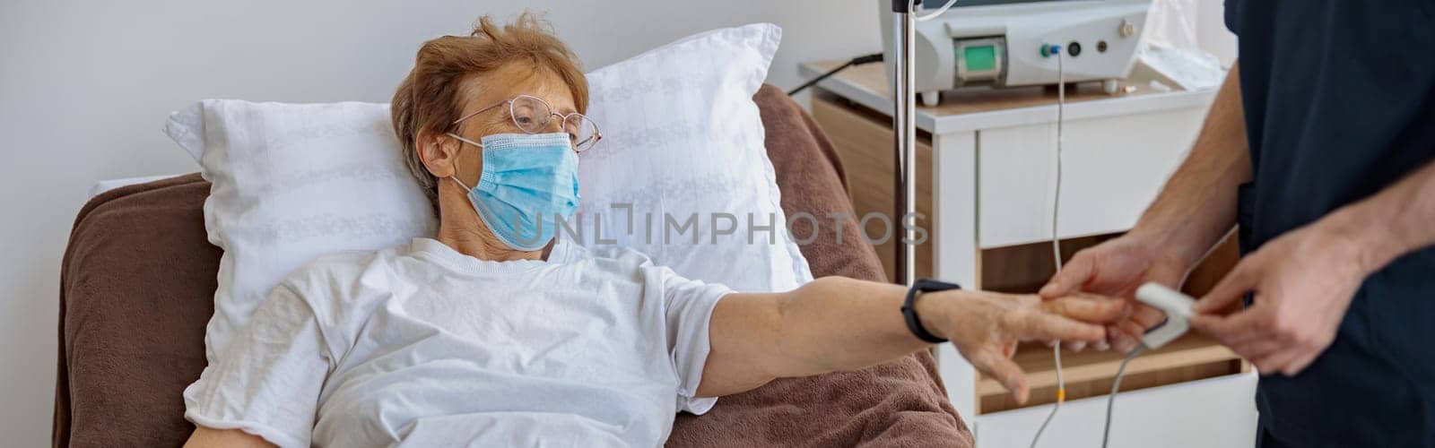 Nurse checking with fingertip pulse oximeter oxygen saturation of patient blood. High quality photo