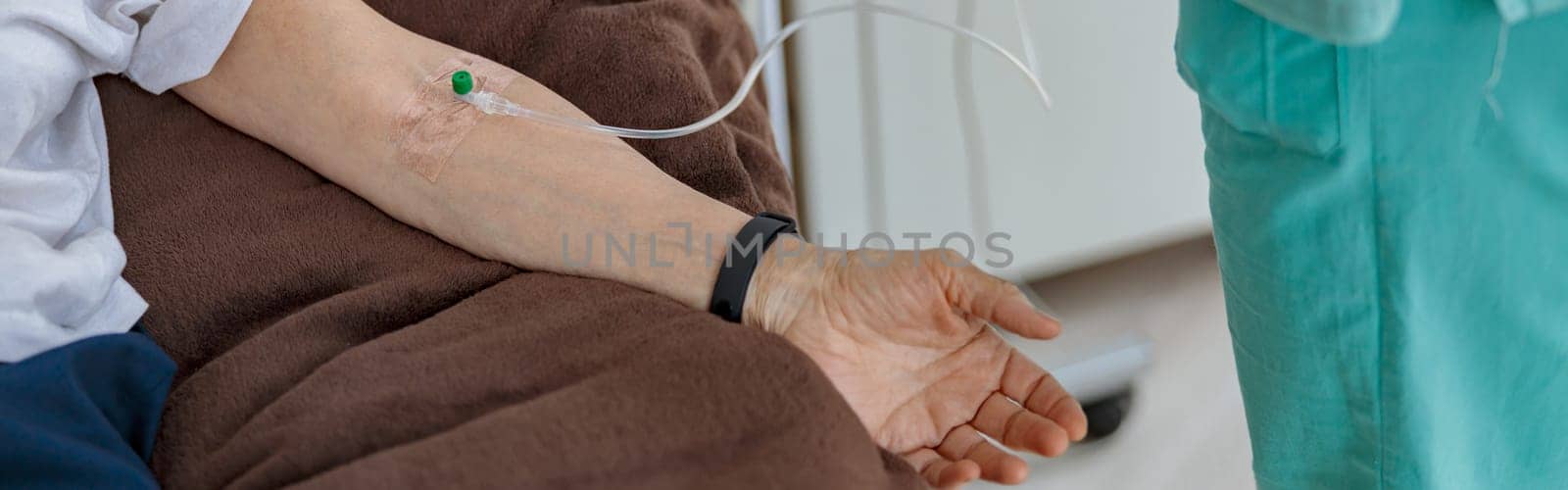 Nurse putting a drip in the arm of her patient in modern medical clinic. High quality photo