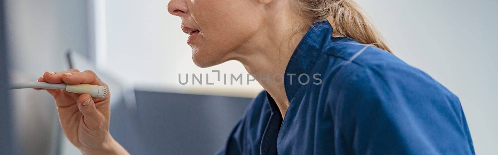 Nurse on Duty makes announcement into microphone sitting at Reception Desk. High quality photo
