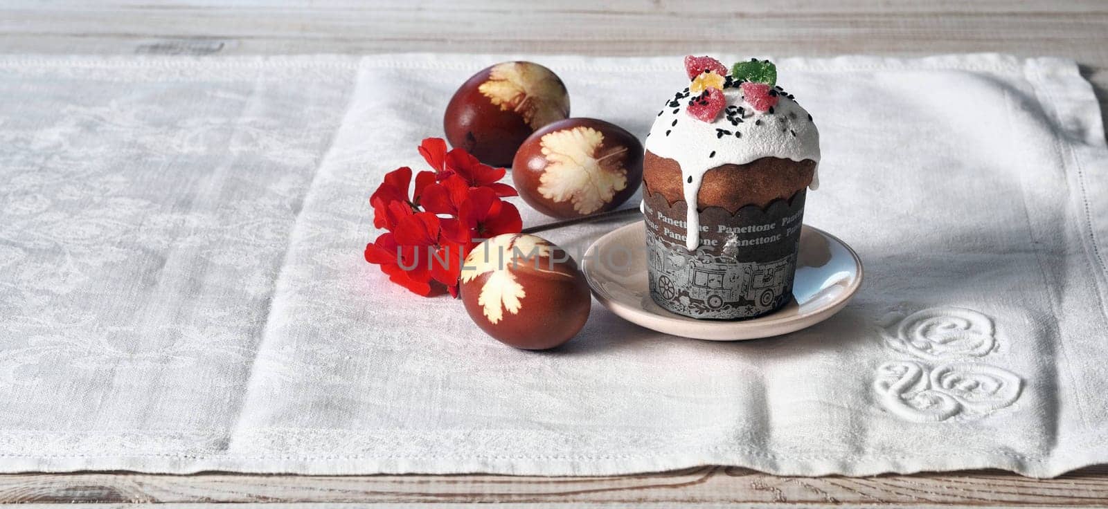 The concept of delicious Easter food, close-up.Easter homemade pastries displayed with eggs and a flower on a white natural tablecloth