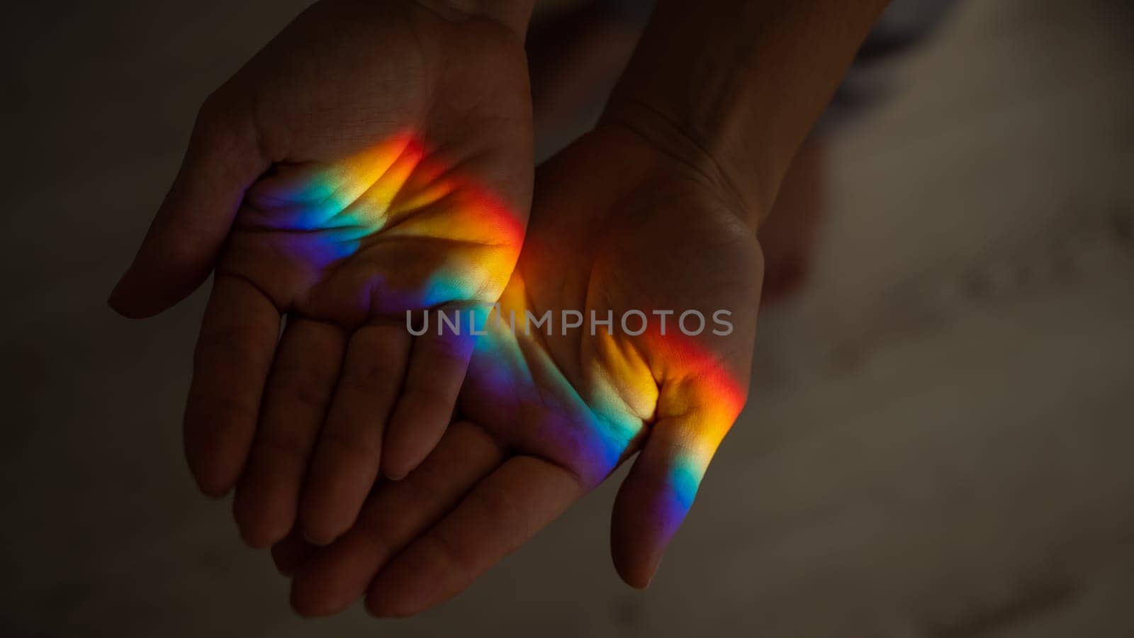 Rainbow ray on a woman's hand. by mrwed54