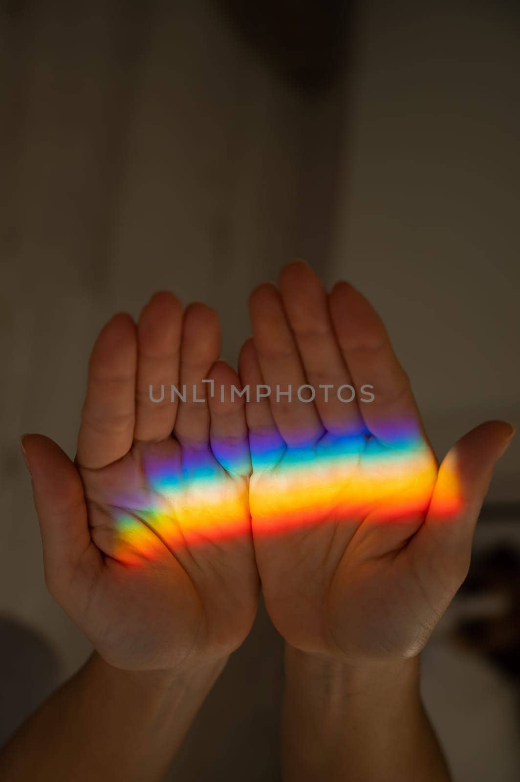 Rainbow ray on a woman's hand. by mrwed54