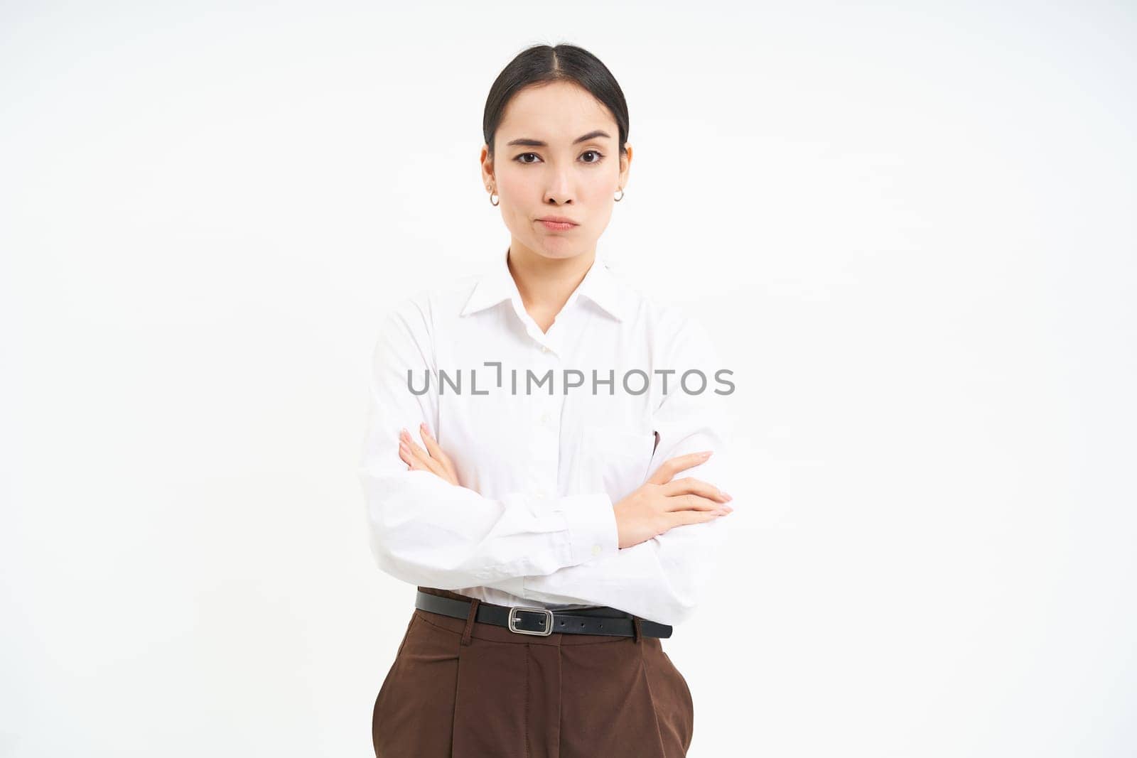 Portrait of upset, offended asian woman, cross arms on chest and looks away, frowning with disappointment, white background.