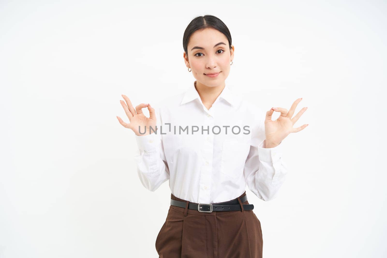 Business. Professional businesswoman, shows okay, approval gesture, recommends smth, white studio background.