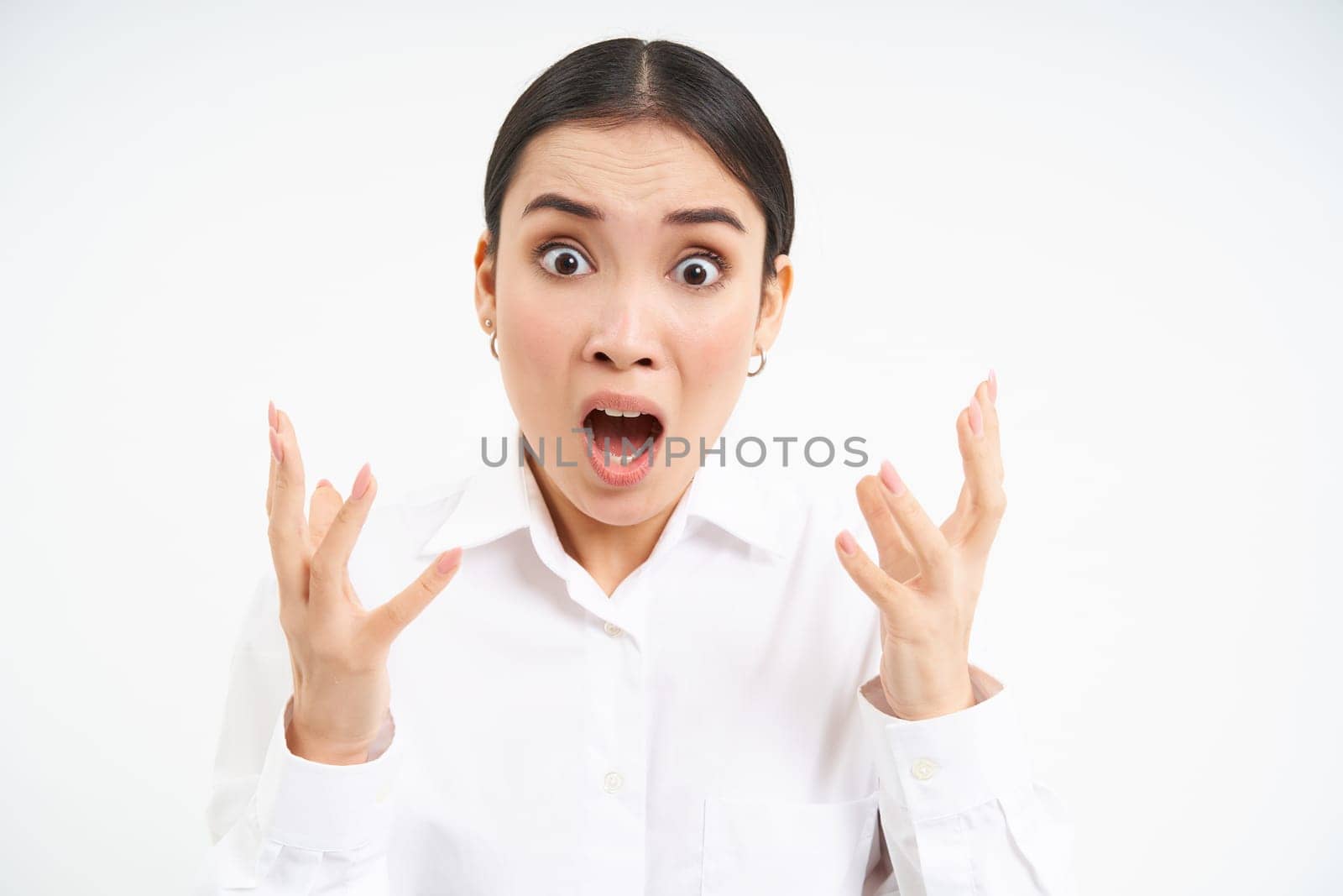 Angry office lady, asian businesswoman screams and clenches fists from anger, shakes from frustrated, stands over white background, loses temper by Benzoix