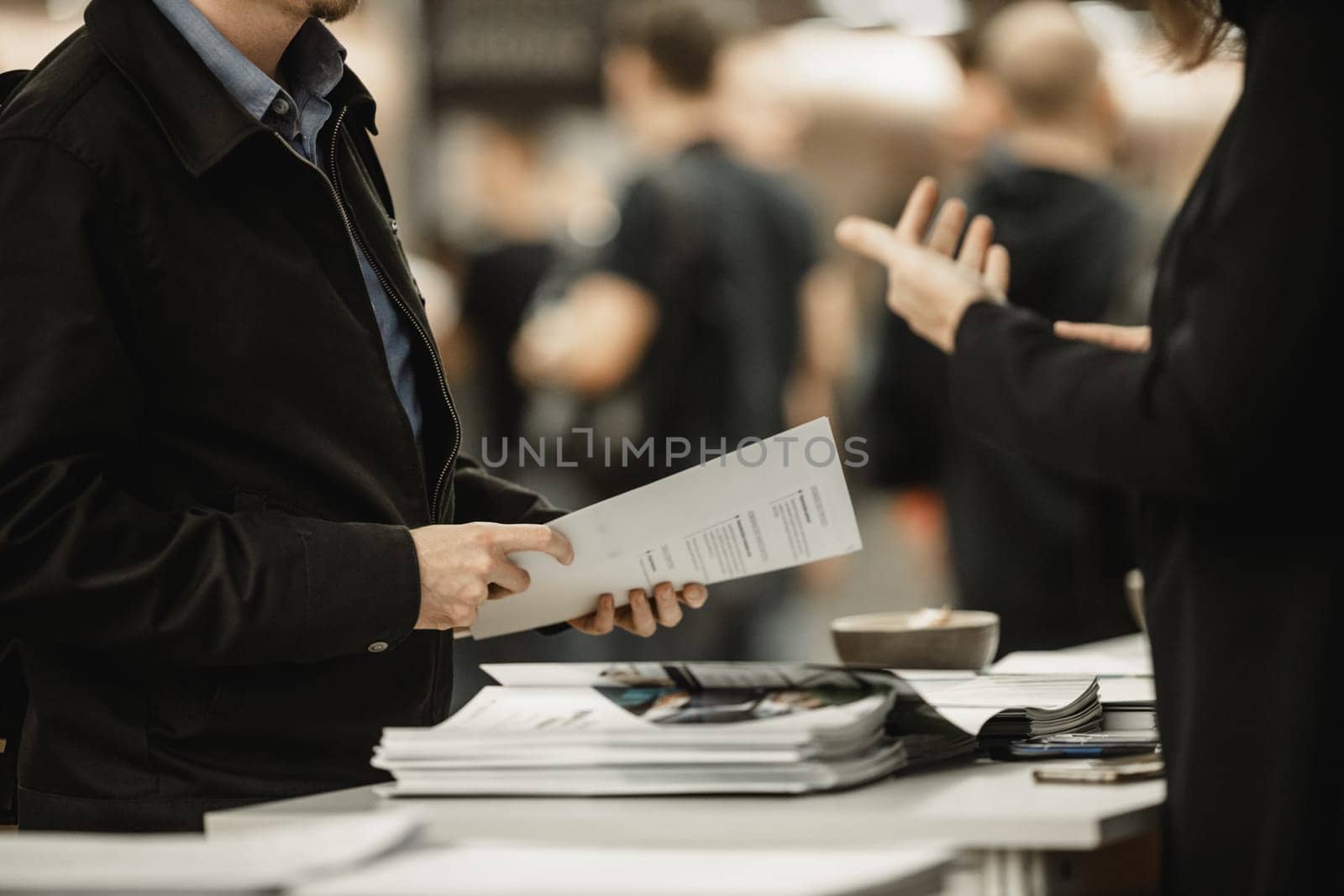 Business people exchanging business promotional materials and brochure on business meeting on trade-show. Business discussion talking deal concept. by kasto