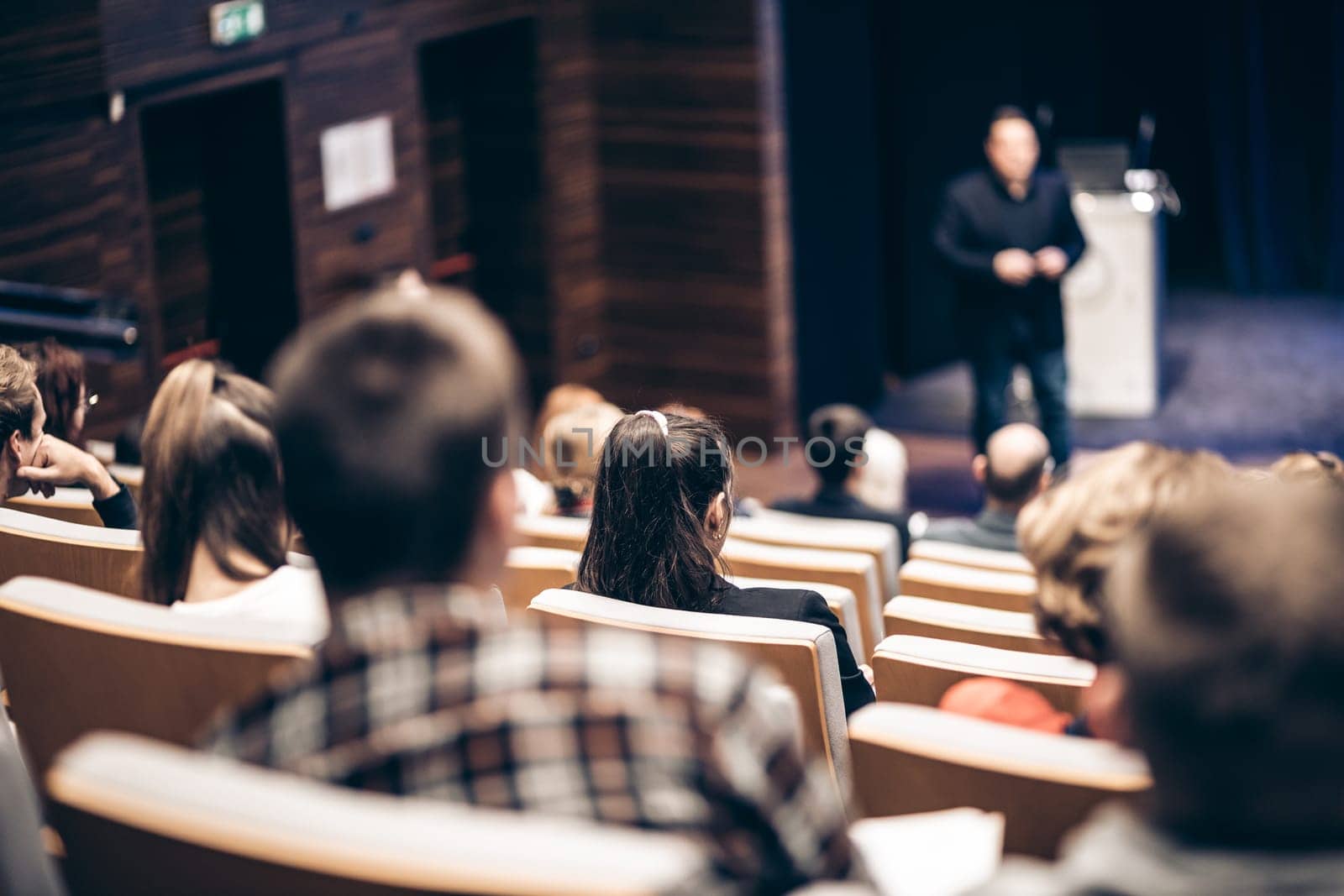 Speaker giving a talk in conference hall at business event. Rear view of unrecognizable people in audience at the conference hall. Business and entrepreneurship concept. by kasto