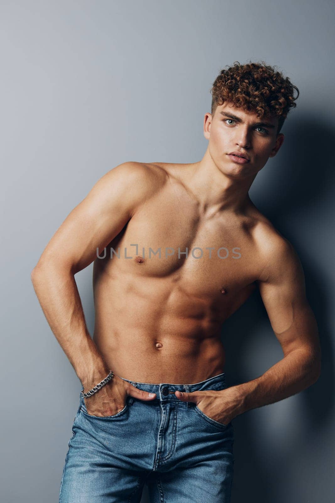 man studio athletic fit smile handsome gray gray background shirtless background athlete naked standing fashion muscular abs curly health bodybuilder male