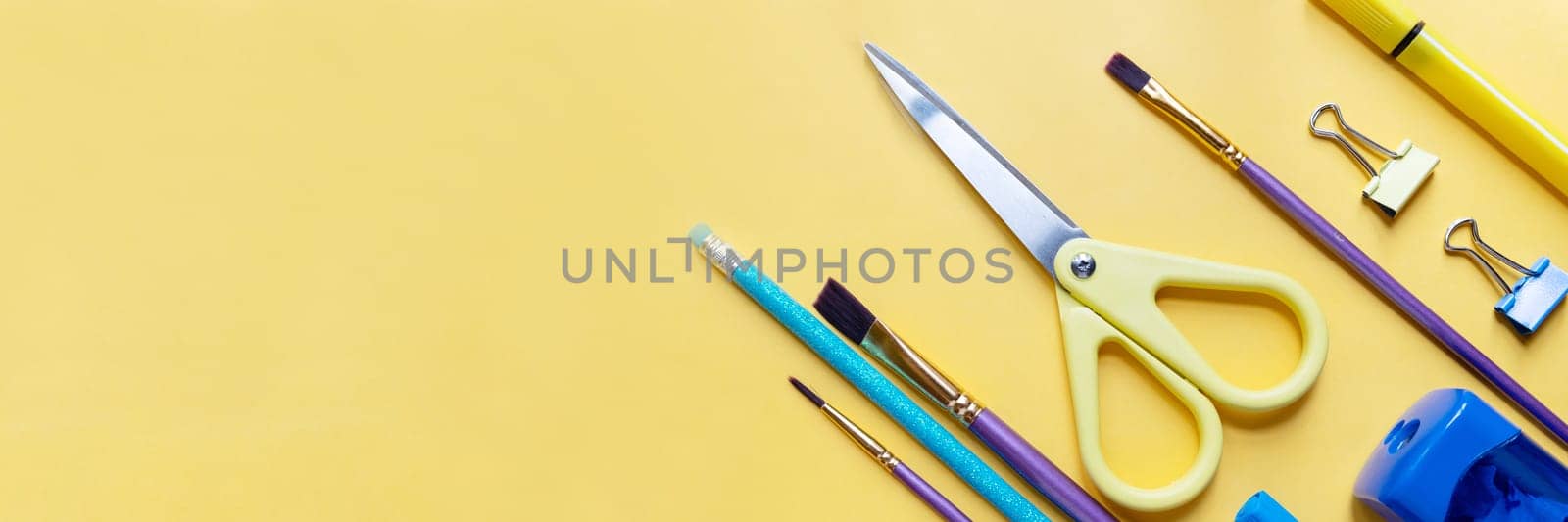 Frame from school and office supplies Paper clips, scissors, pens, felt-tip pens, sharpener, isolated on yellow background. Flat lay.Back to school, education concept.Teacher's Day. by YuliaYaspe1979