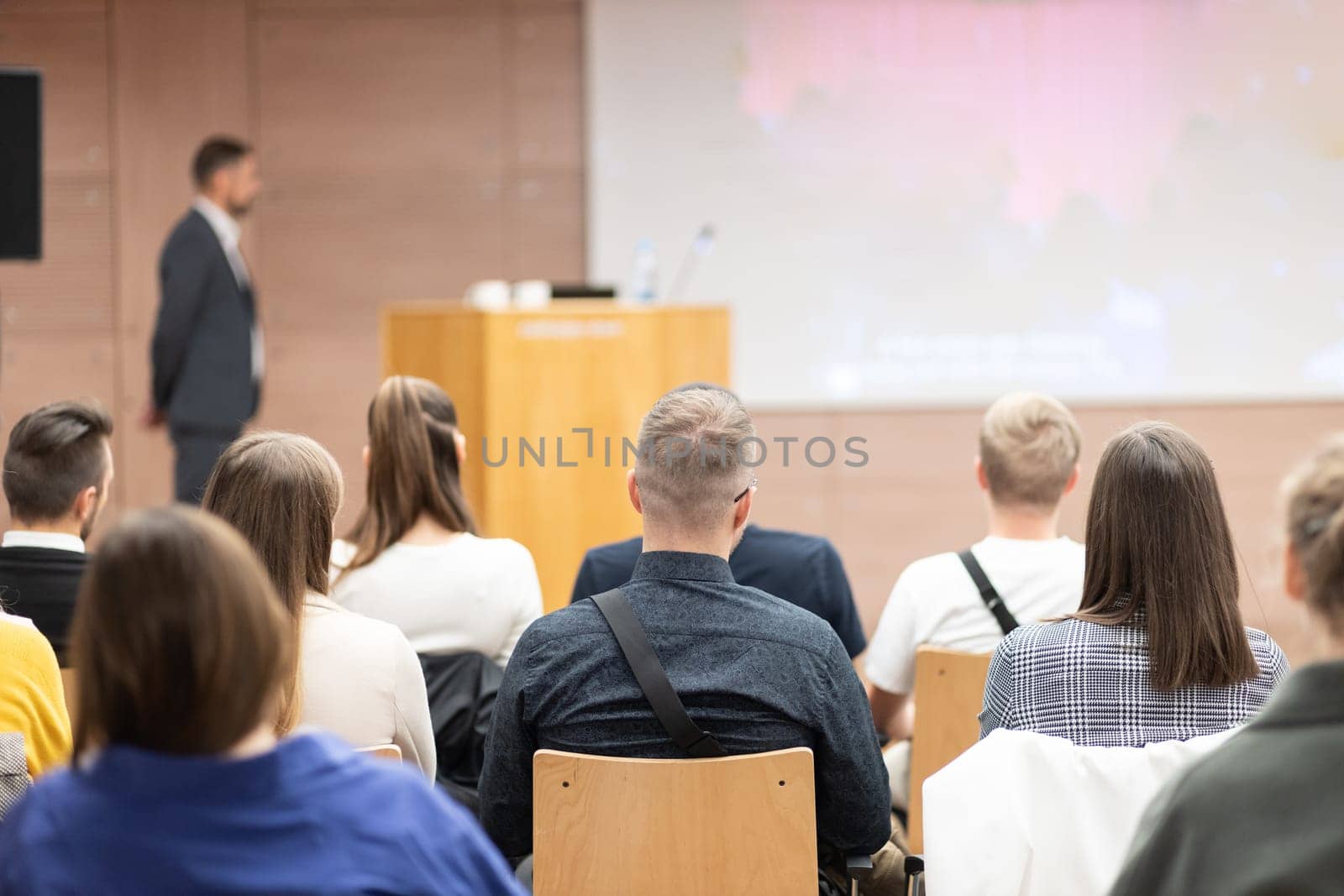 Speaker giving a talk in conference hall at business event. Rear view of unrecognizable people in audience at the conference hall. Business and entrepreneurship concept. by kasto