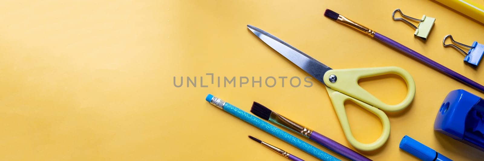 Frame from school and office supplies Paper clips, scissors, pens, felt-tip pens, sharpener, isolated on yellow background. Flat lay.Back to school, education concept.Teacher's Day. by YuliaYaspe1979