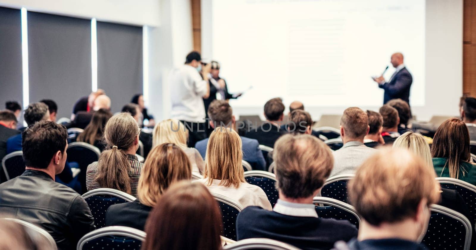 I have a question. Group of business people sitting in conference hall. Businessman raising his arm. Conference and Presentation. Business and Entrepreneurship by kasto