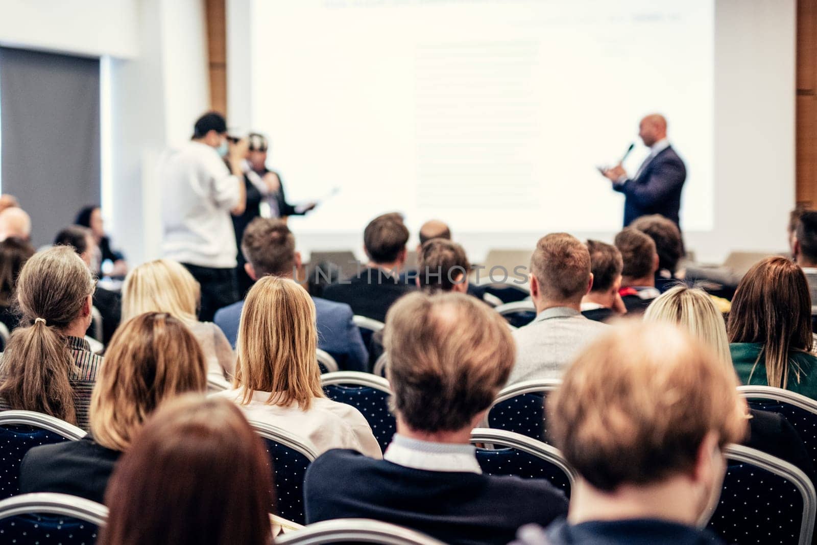 I have a question. Group of business people sitting in conference hall. Businessman raising his arm. Conference and Presentation. Business and Entrepreneurship by kasto