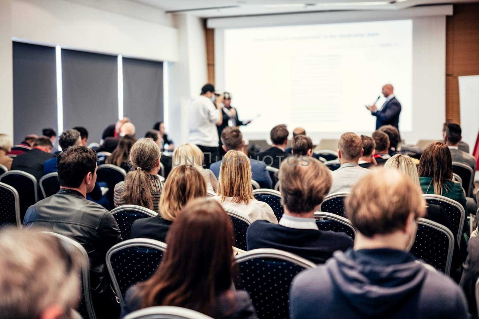 I have a question. Group of business people sitting in conference hall. Businessman raising his arm. Conference and Presentation. Business and Entrepreneurship by kasto