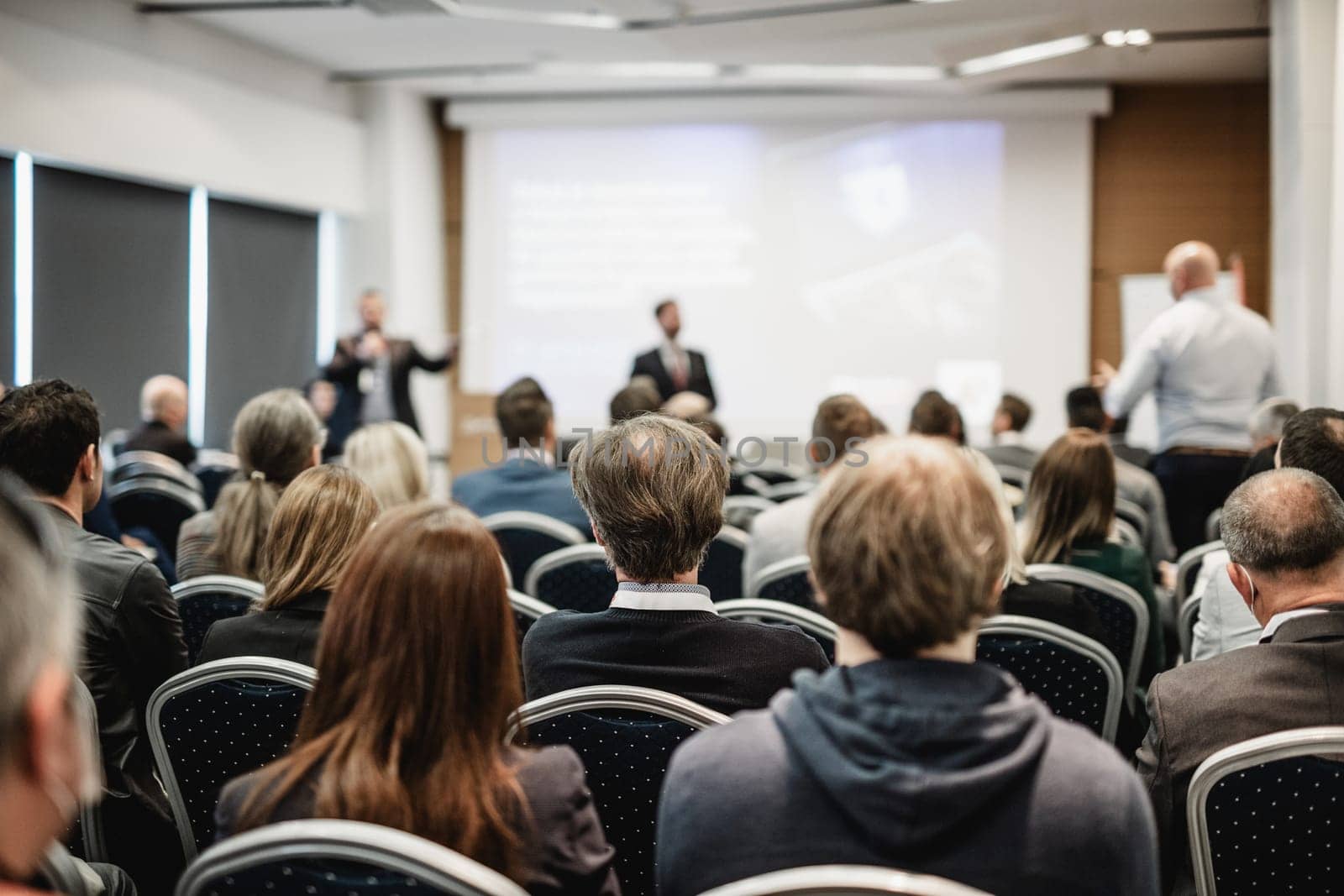 I have a question. Group of business people sitting in conference hall. Businessman raising his arm. Conference and Presentation. Business and Entrepreneurship by kasto