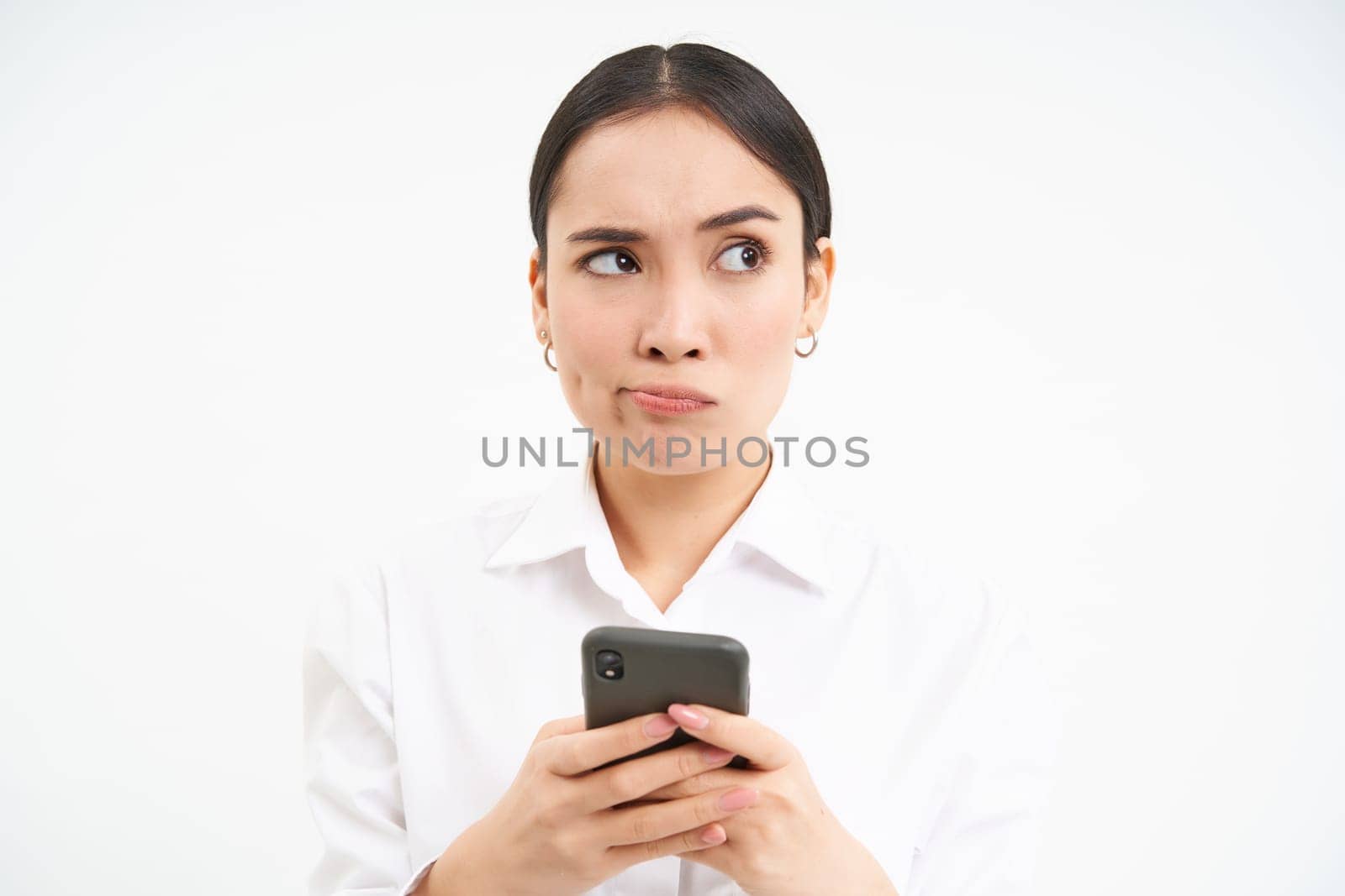 Image of asian saleswoman, office manager holding smartphone, working on text for social media, using cellphone, white background.