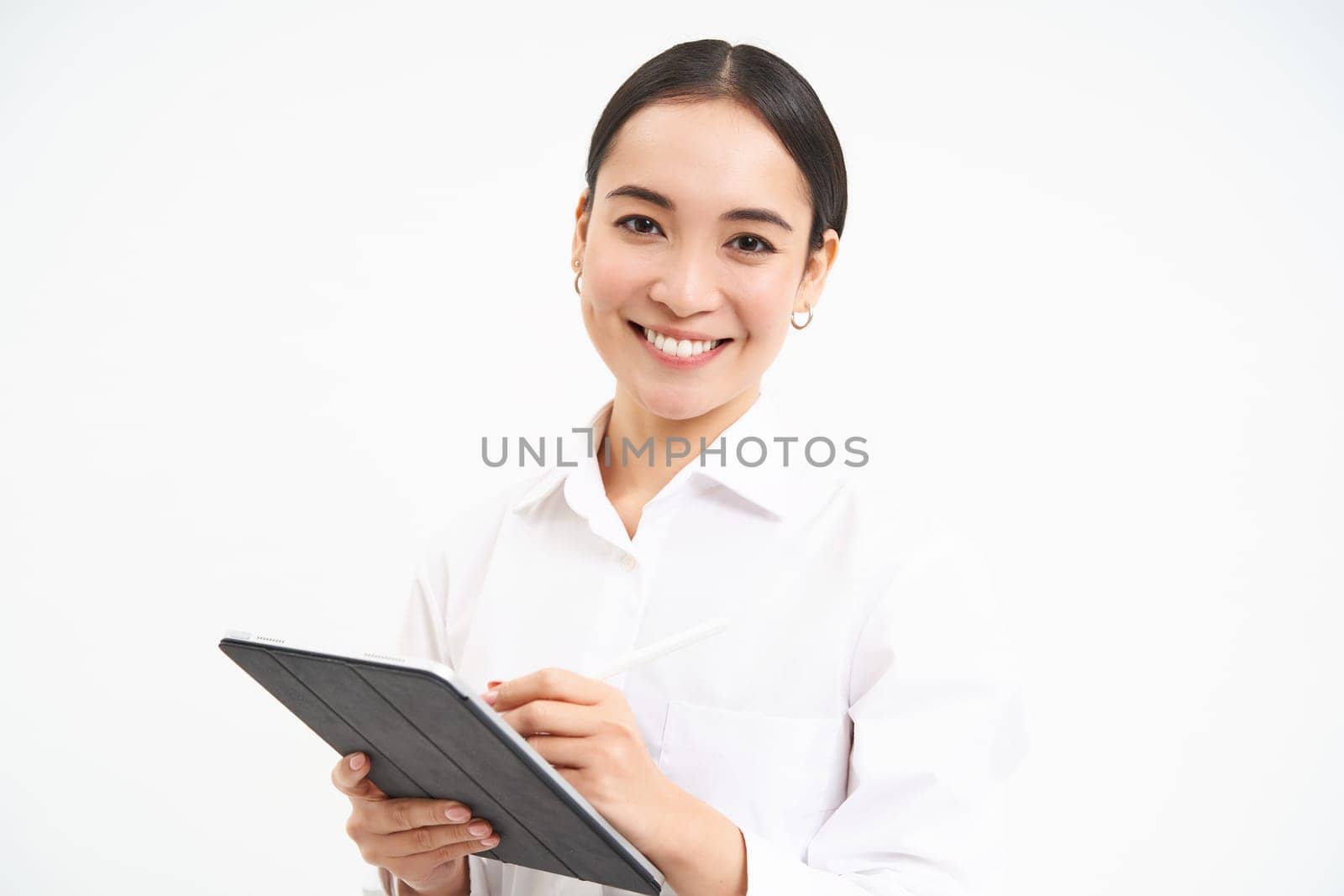 Portrait of businesswoman working on digital tablet, creating diagrams for meeting conference on gadget, standing over white background.