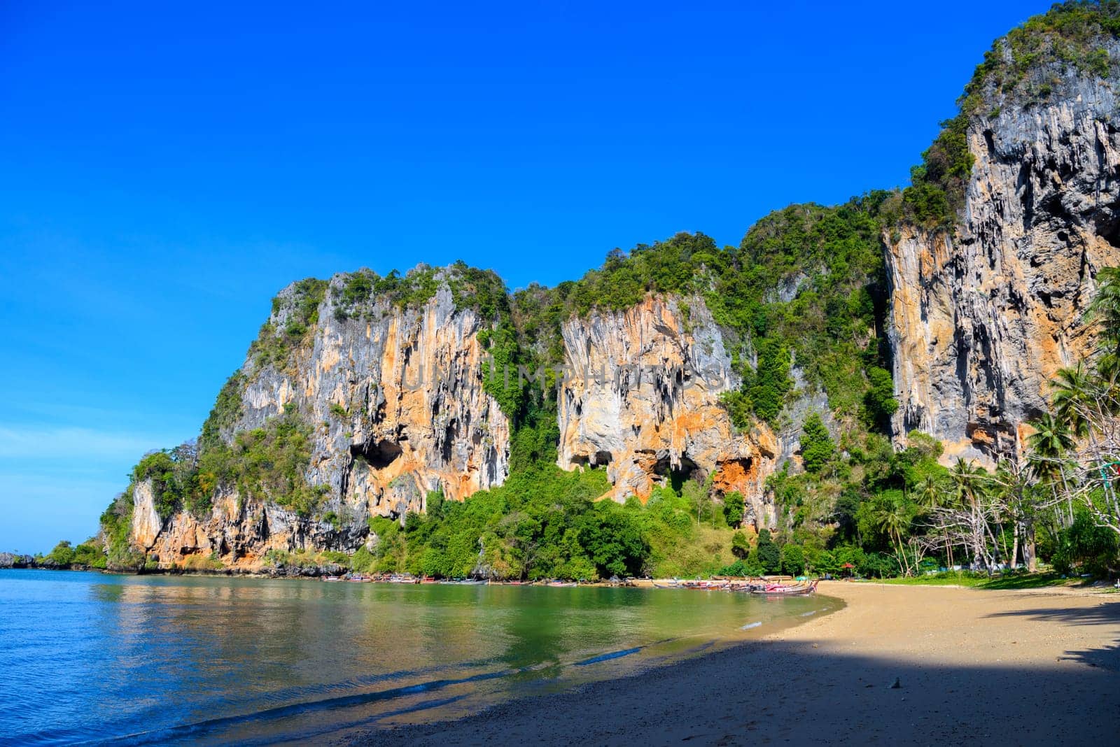 Long tail boats along cliff rocks near the beach, Tonsai Bay, Railay Beach, Ao Nang, Krabi, Thailand by Eagle2308