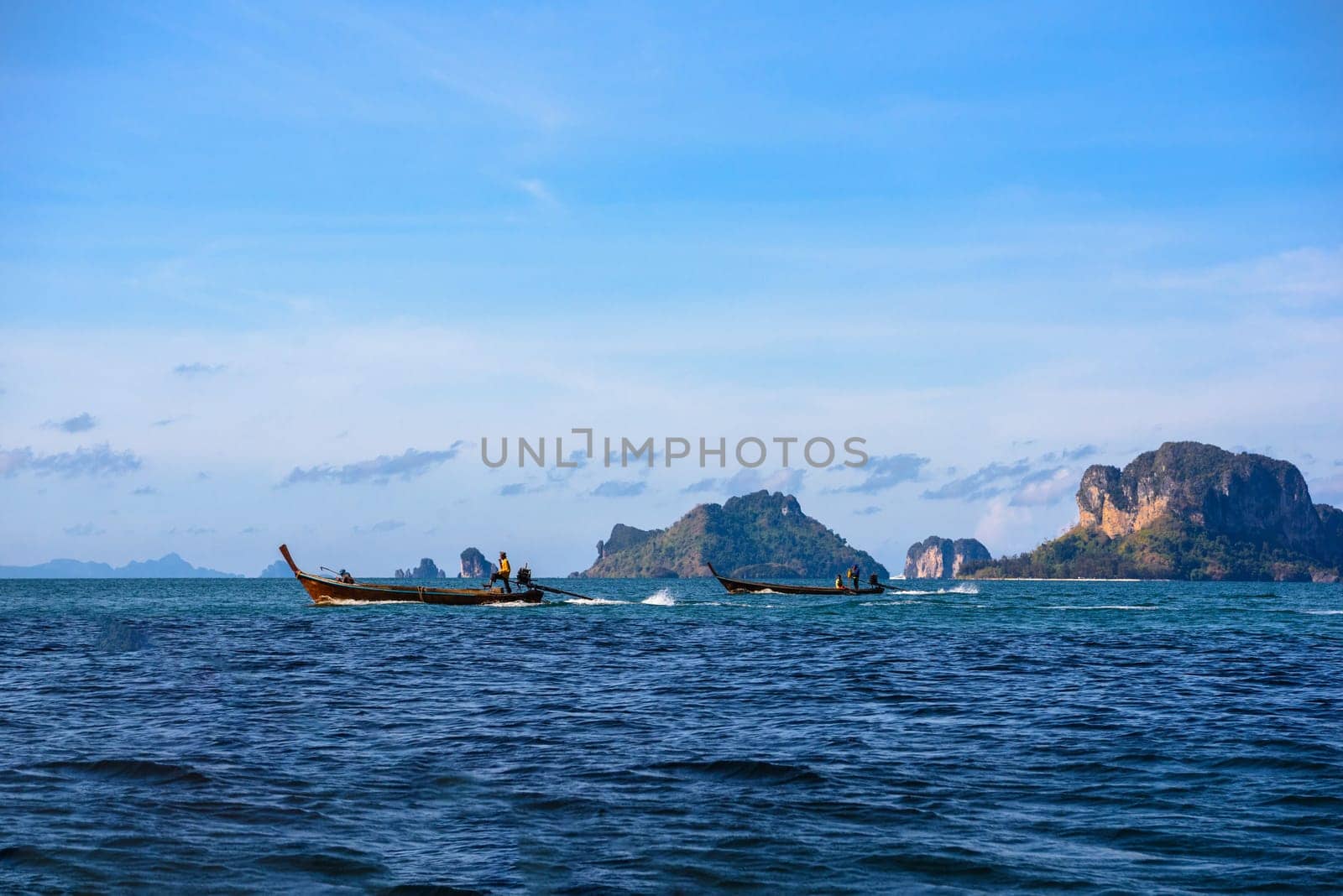 Men in long tail boats with Ko Poda and Ko Kai Chicken Island in the background, Tonsai Bay, Railay Beach, Ao Nang, Krabi, Thailand.