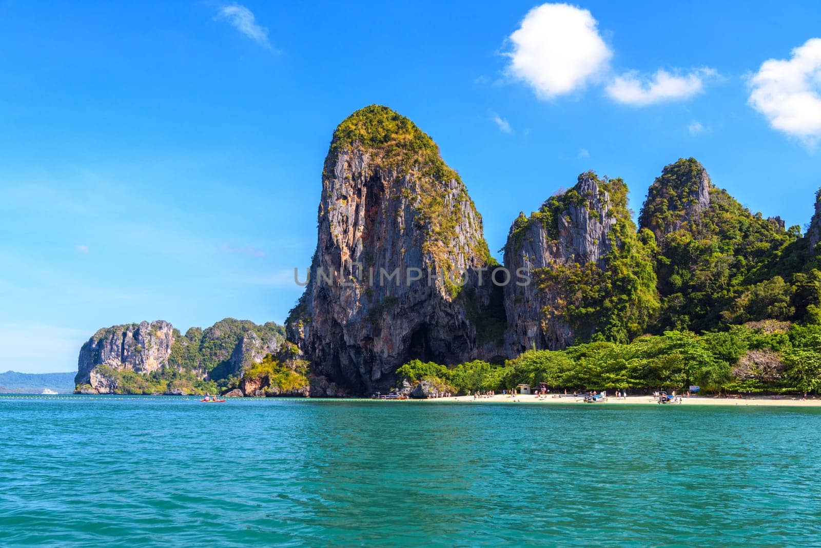 People sunbating near huge cliff rocks on Ao Phra Nang Beach, Ao Nang, Krabi, Thailand.