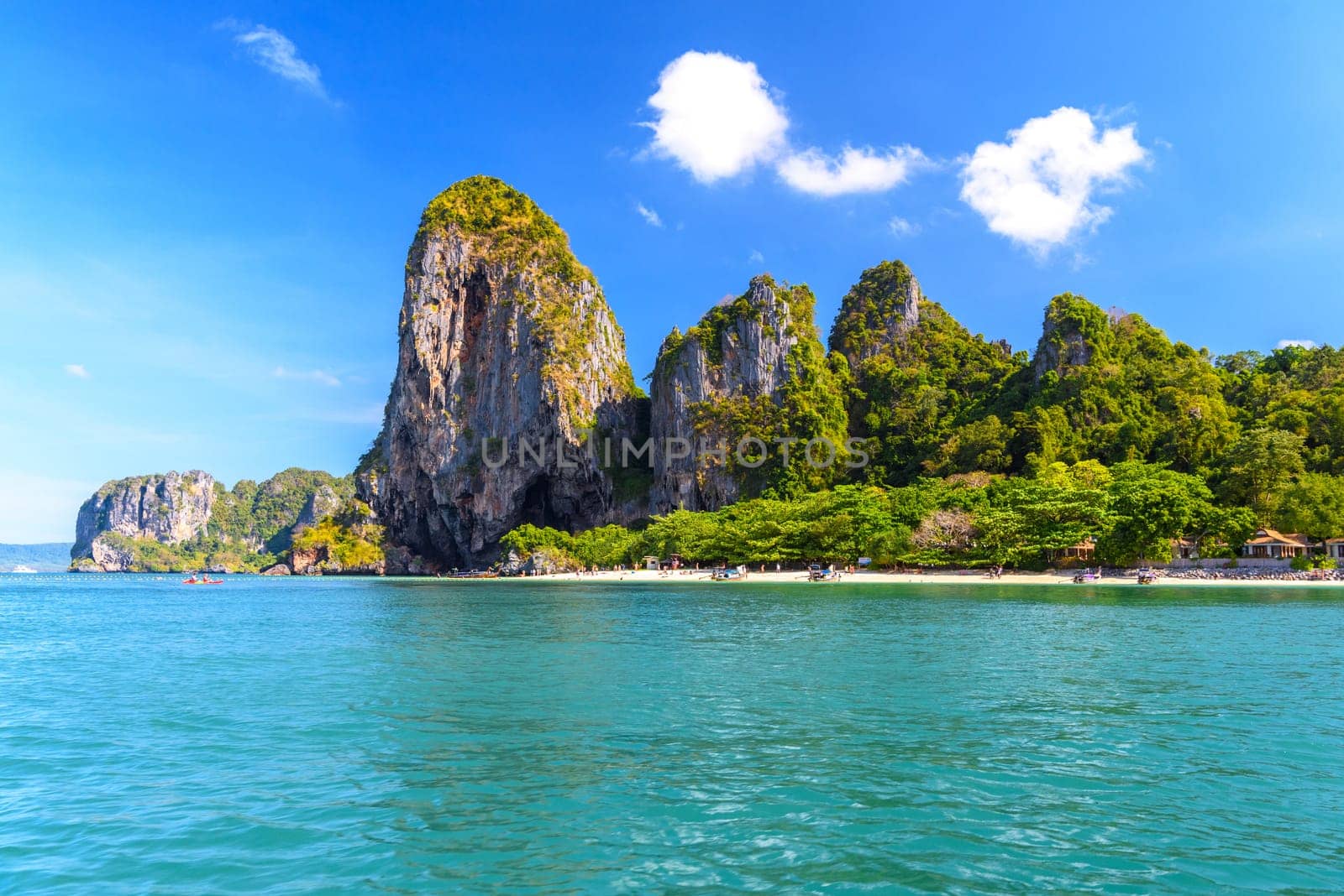 People sunbating near huge cliff rocks on Ao Phra Nang Beach, Ao Nang, Krabi, Thailand.