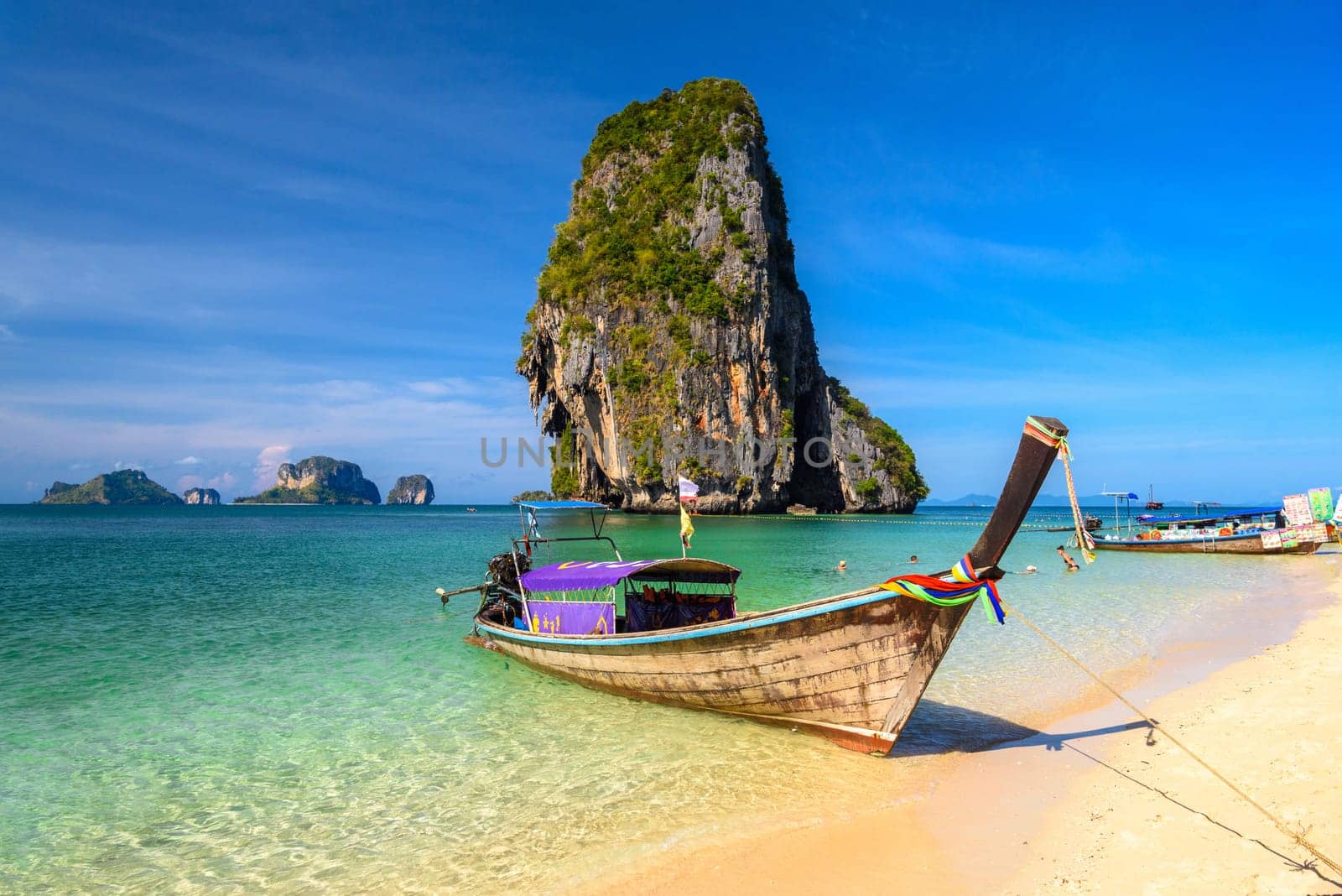 Long tail boats and cliff rock in azure water, Ko Rang Nok, Ao Phra Nang Beach, Ao Nang, Krabi, Thailand.