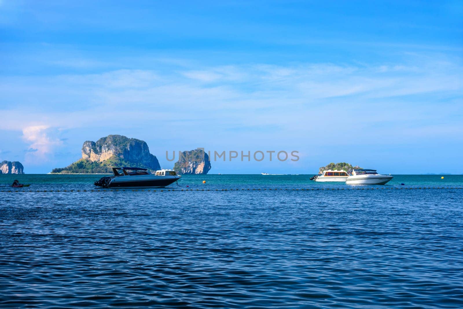 Speed boats in the sea with cliff rocks in the background, Ao Phra Nang Beach, Ao Nang, Krabi, Thailand.