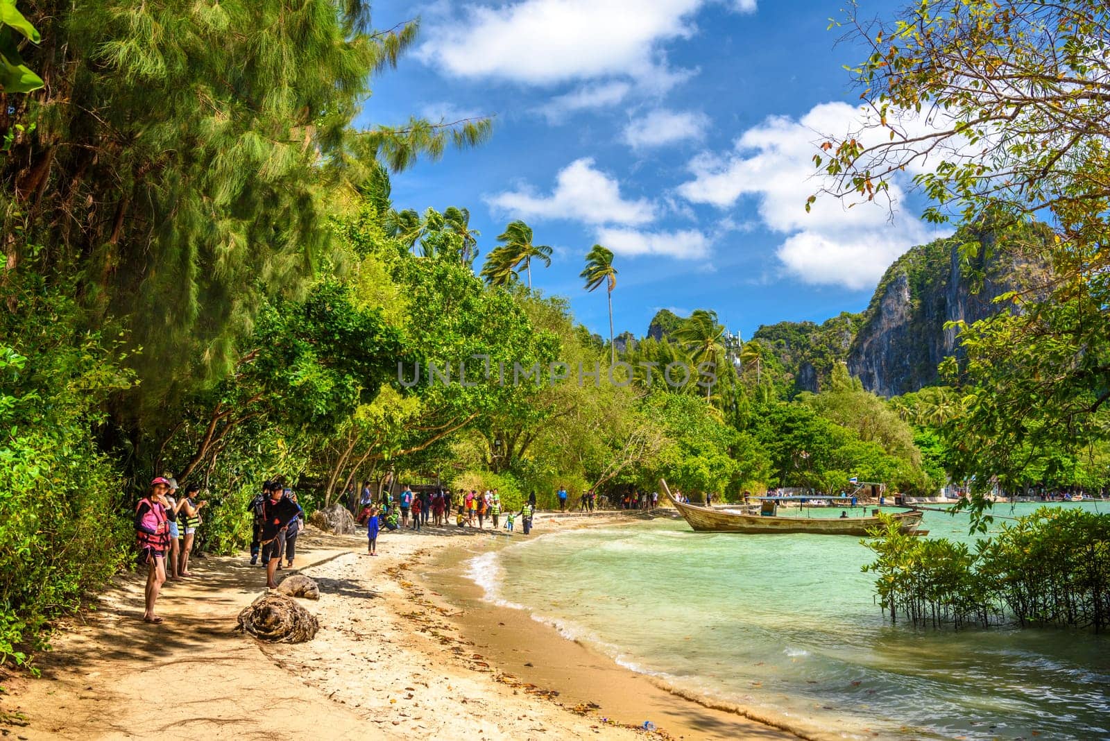 Tourists people, long boats, tropical trees and azure water on Ao Phra Nang Beach, Railay east Ao Nang, Krabi, Thailand by Eagle2308