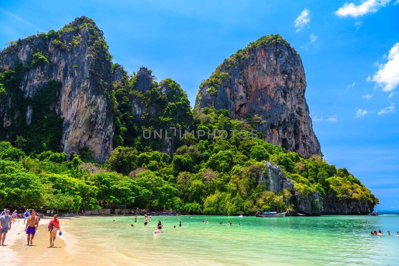 Rocks, water, tropical white sand beach and people swimming in emerald azure water of bay, Railay beach west, Ao Nang, Krabi, Thailand by Eagle2308
