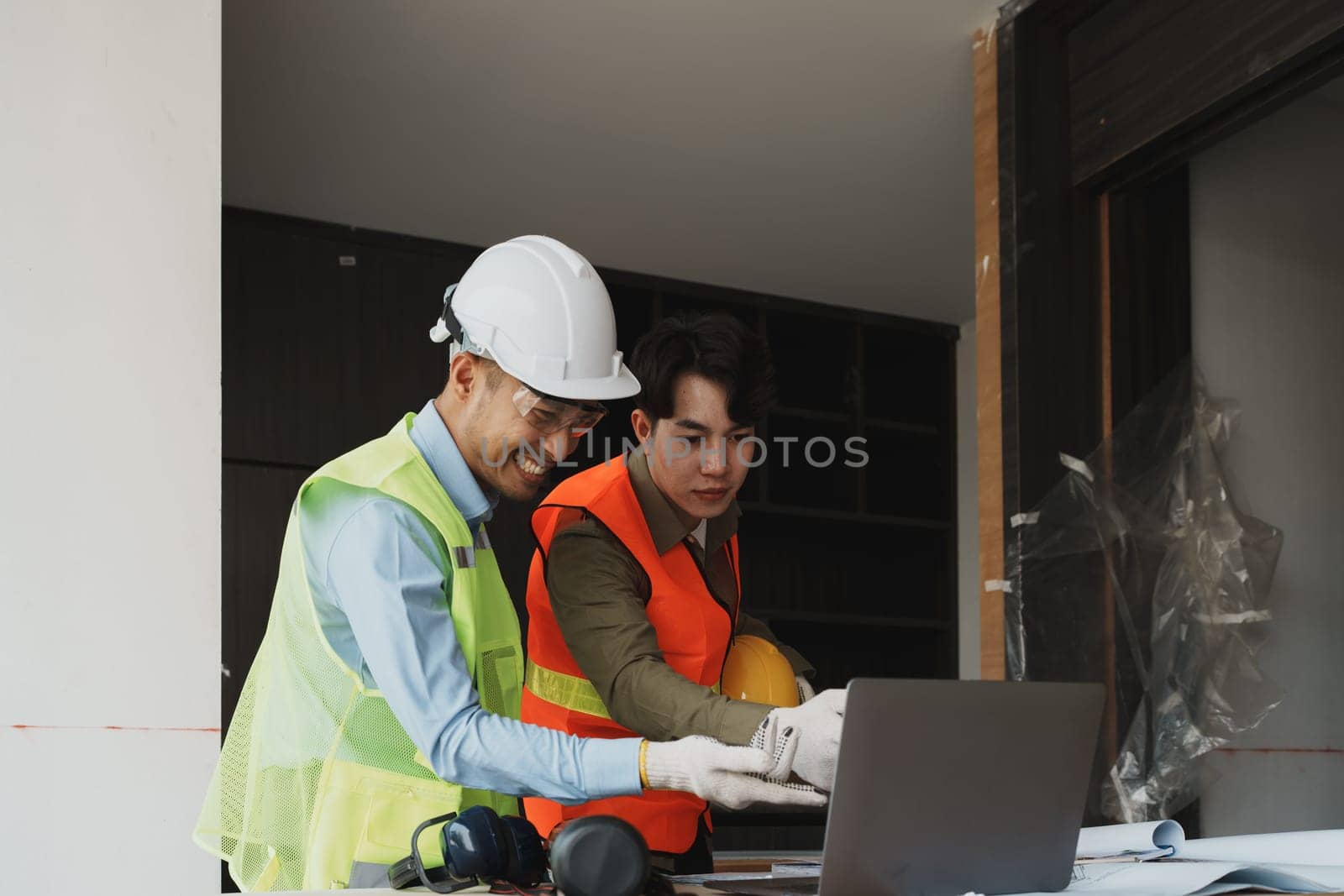 multi ethnic engineer brainstorming and measuring for cost estimating on blueprint and floor plan drawings about design architectural and engineering for houses and buildings by Manastrong