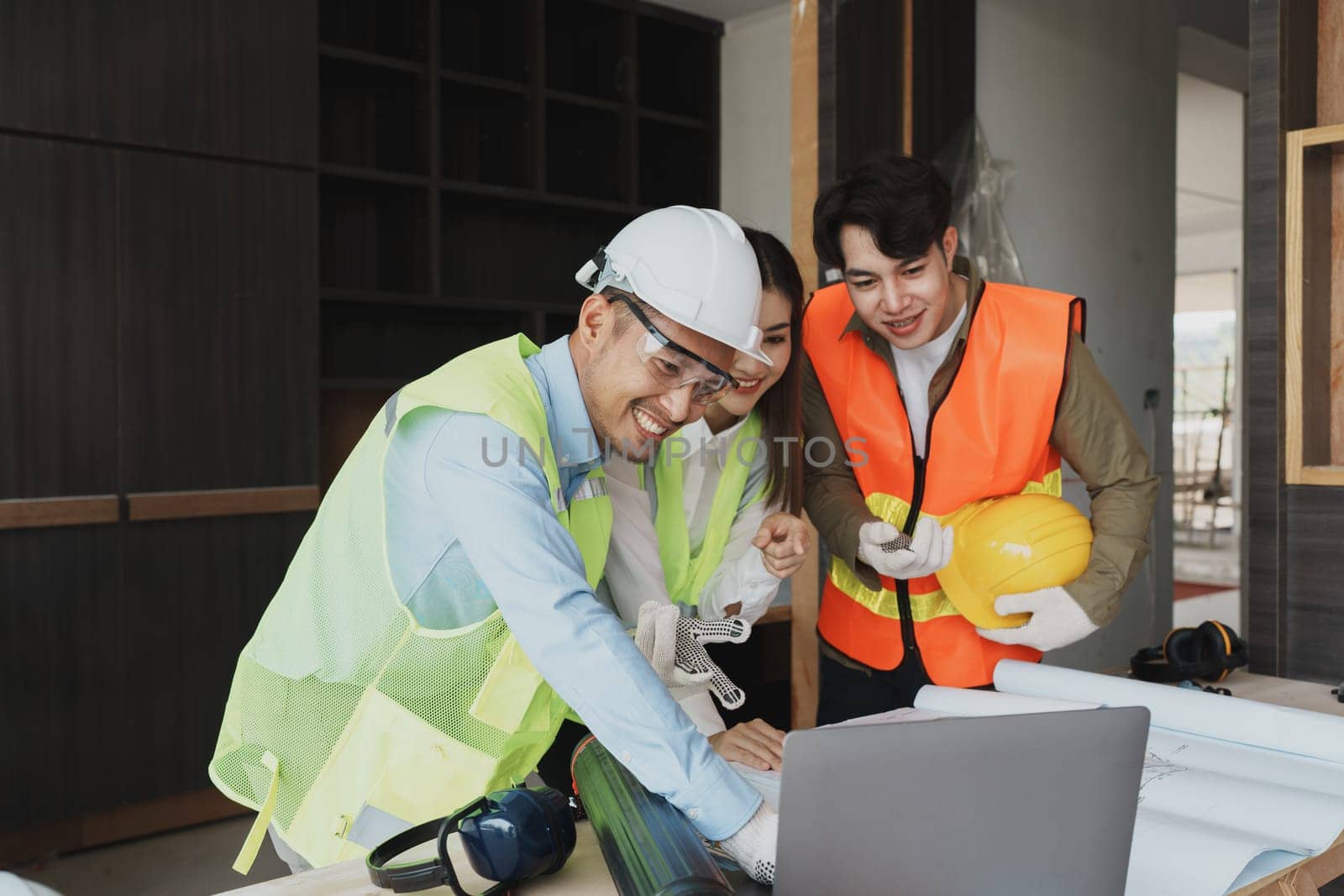 multi ethnic engineer brainstorming and measuring for cost estimating on blueprint and floor plan drawings about design architectural and engineering for houses and buildings.