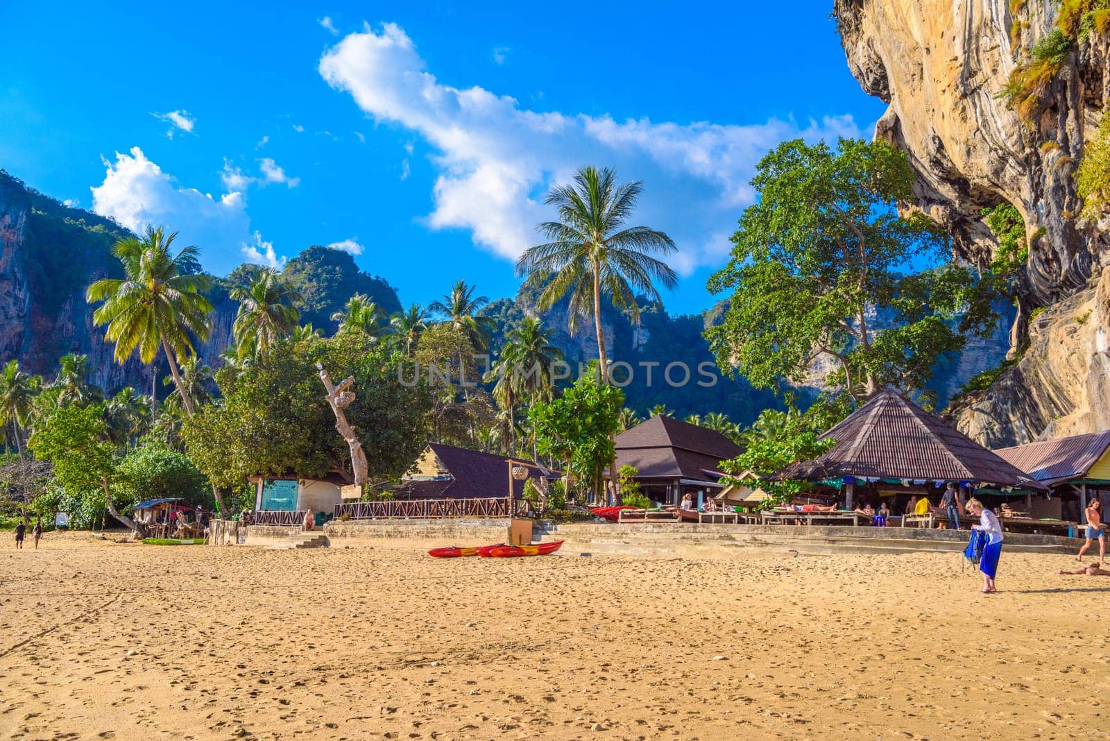 Buildings and palms near rock on Tonsai Bay, Railay Beach, Ao Nang, Krabi, Thailand.