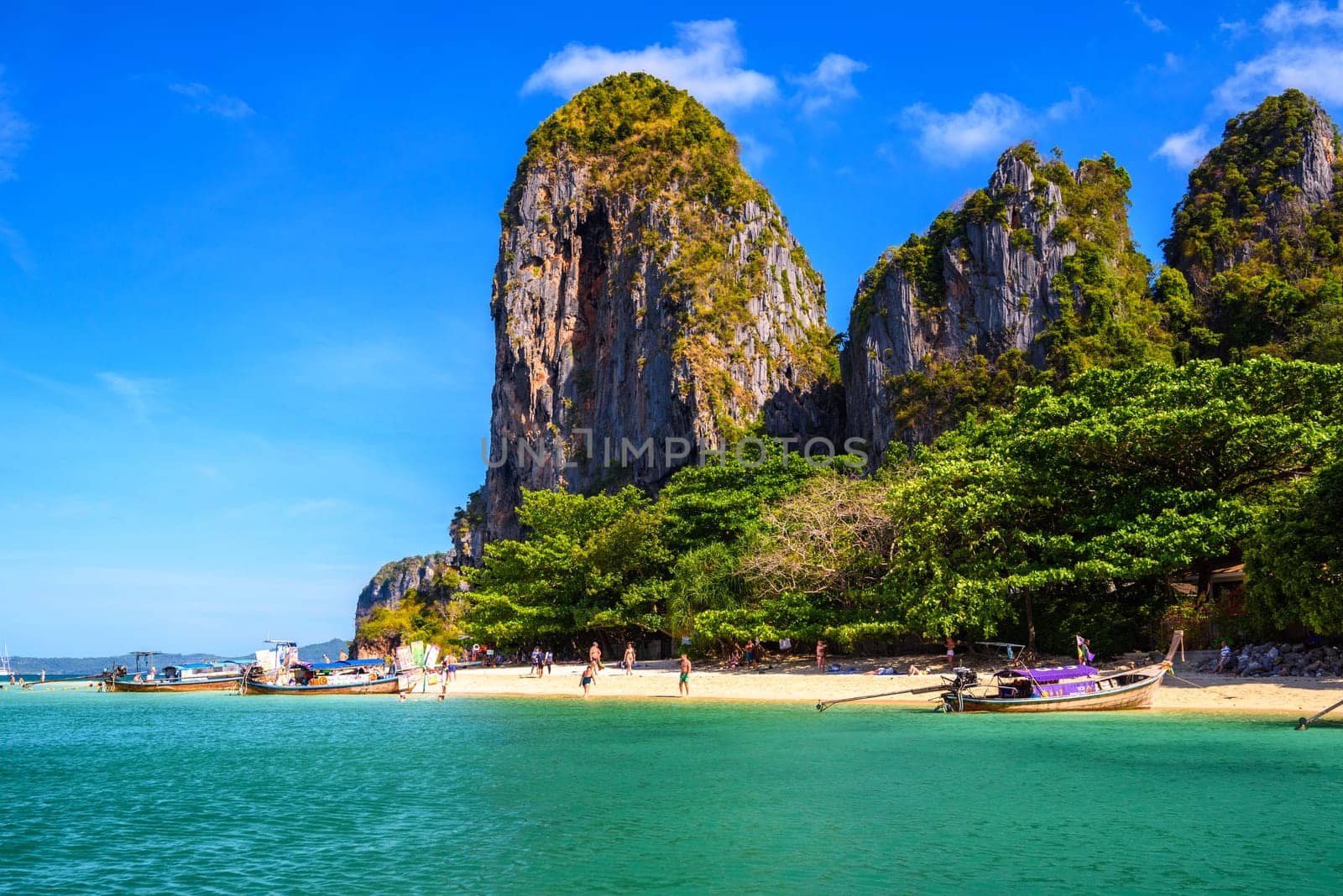 KRABI, THAILAND- MARCH 2018: People sunbating near huge cliff rocks on Ao Phra Nang Beach, Ao Nang, Krabi, Thailand.