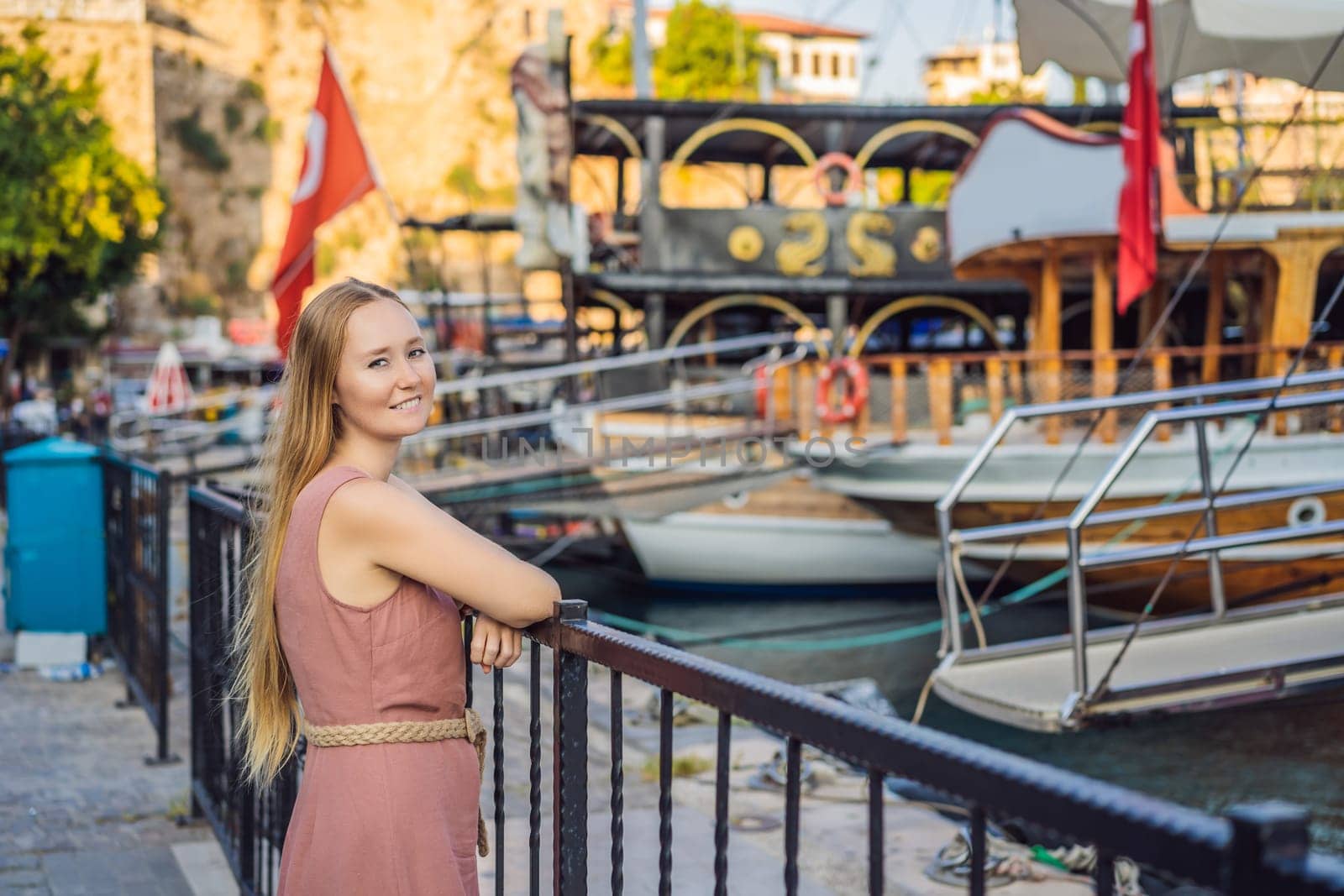Woman tourist in Old town Kaleici in Antalya. Turkiye. Panoramic view of Antalya Old Town port, Taurus mountains and Mediterrranean Sea, Turkey.