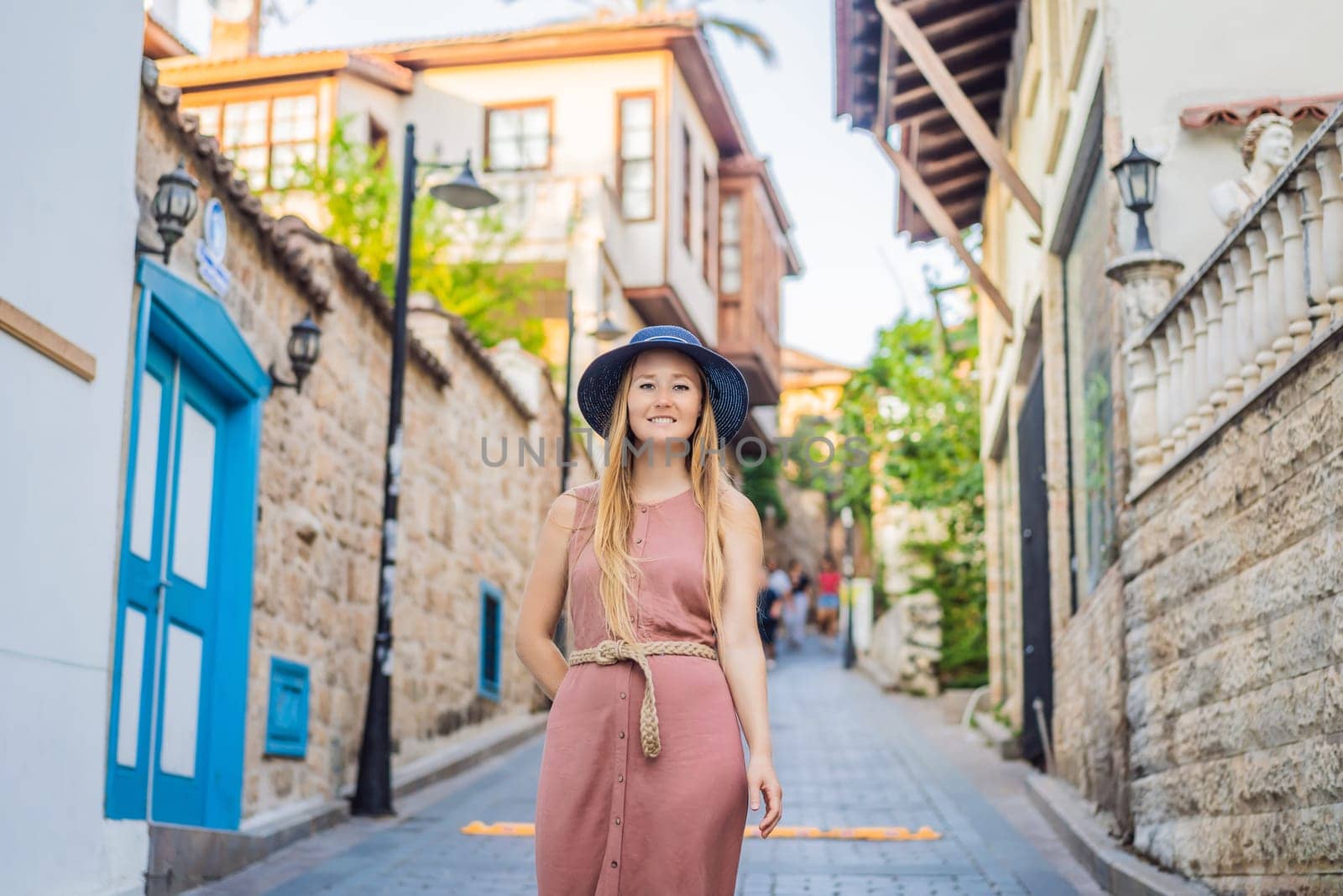 Woman tourist in Old town Kaleici in Antalya. Turkiye. Panoramic view of Antalya Old Town port, Taurus mountains and Mediterrranean Sea, Turkey.
