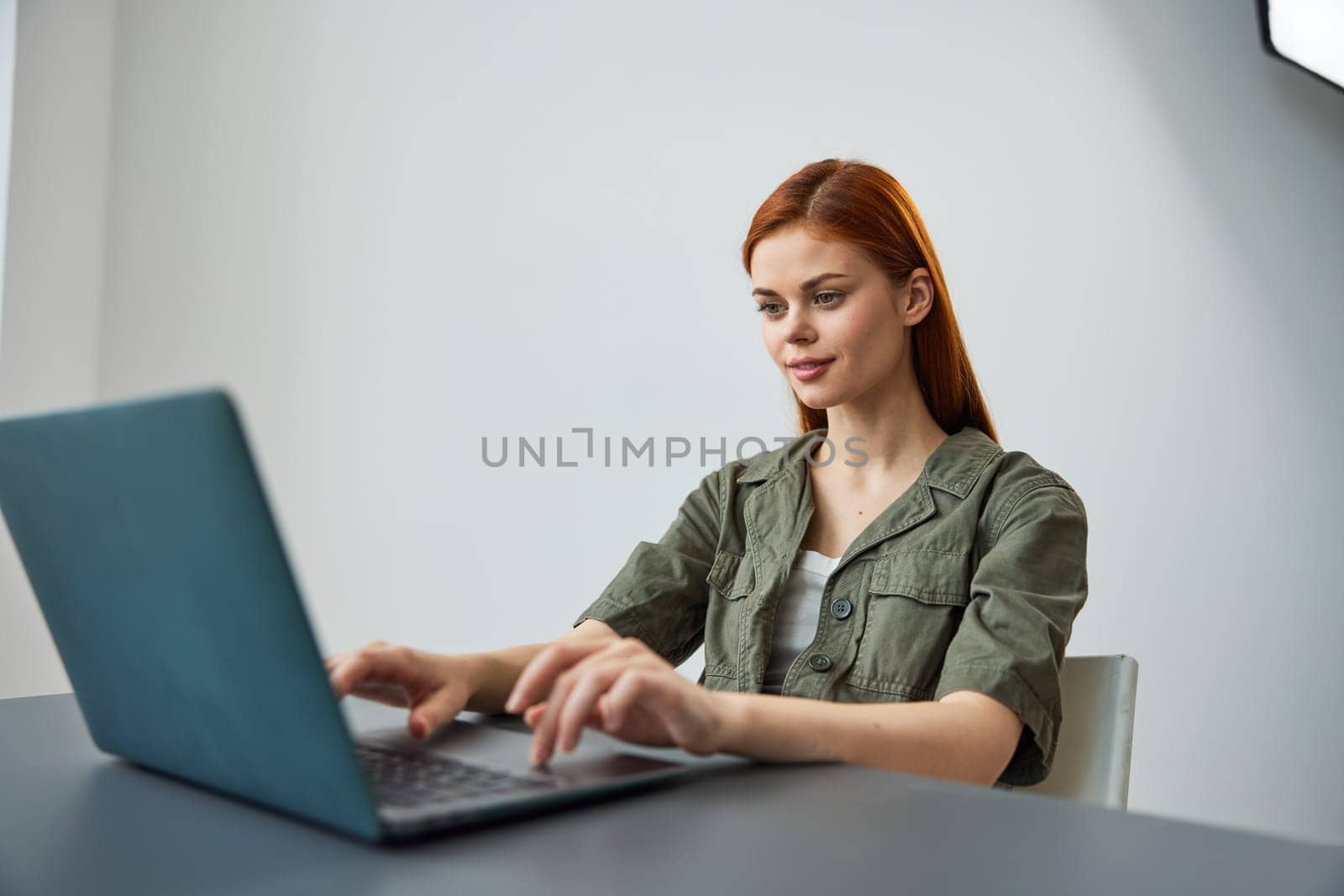 portrait of a cute woman sitting at work at a laptop and thinking things over. High quality photo